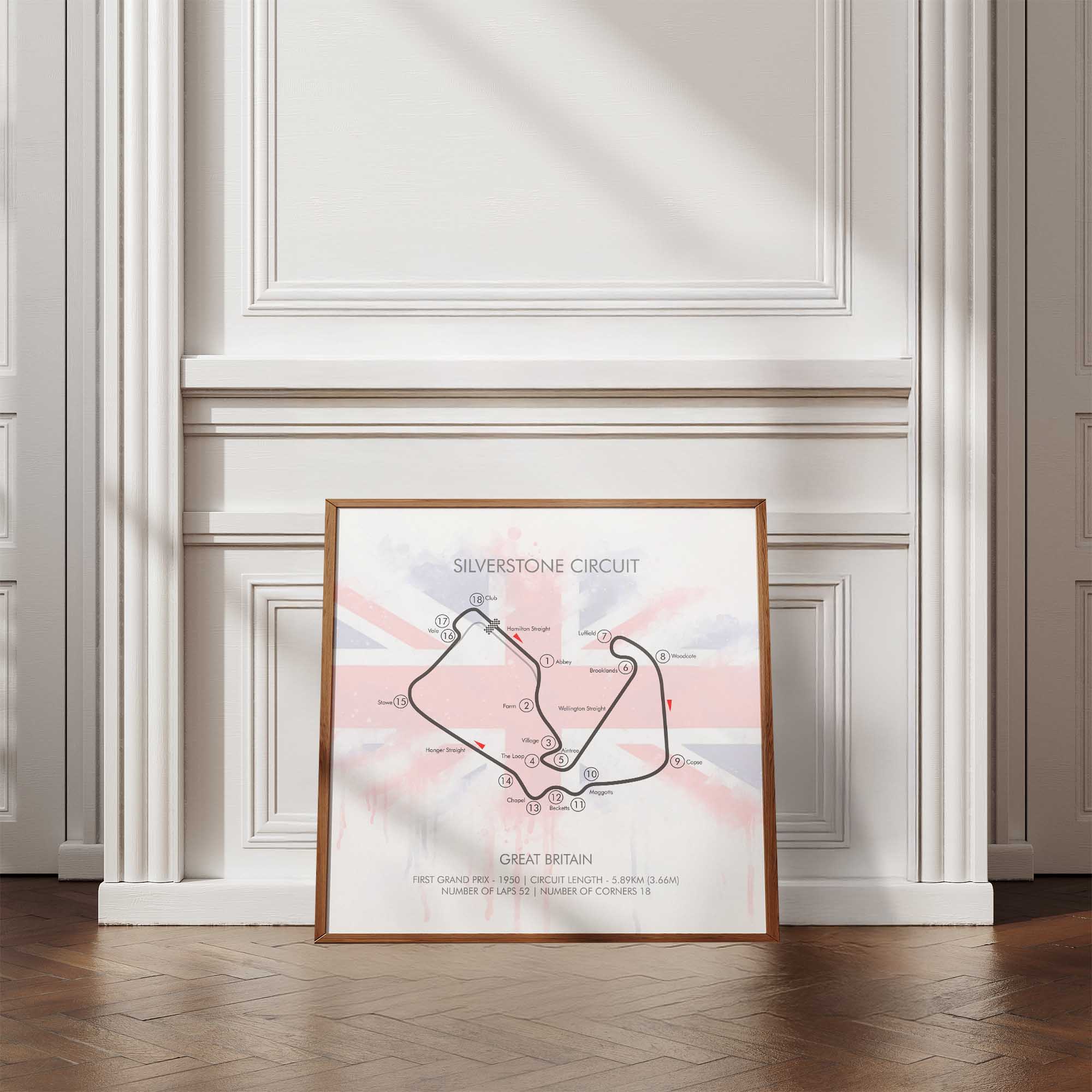Framed map of Silverstone Circuit on a wall with wooden floor and white paneling.
