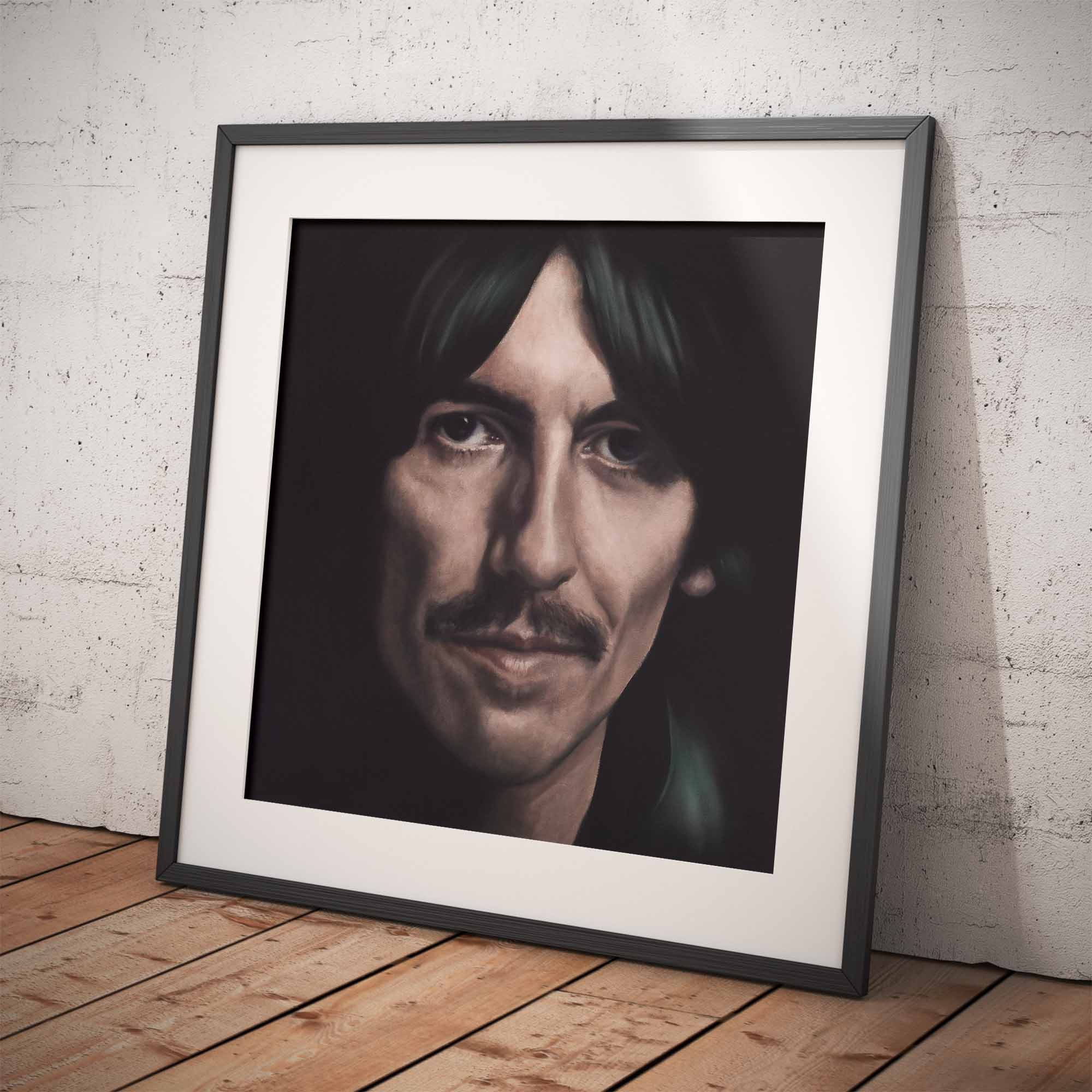 Framed portrait of George Harrison on a wooden floor with a white brick wall background