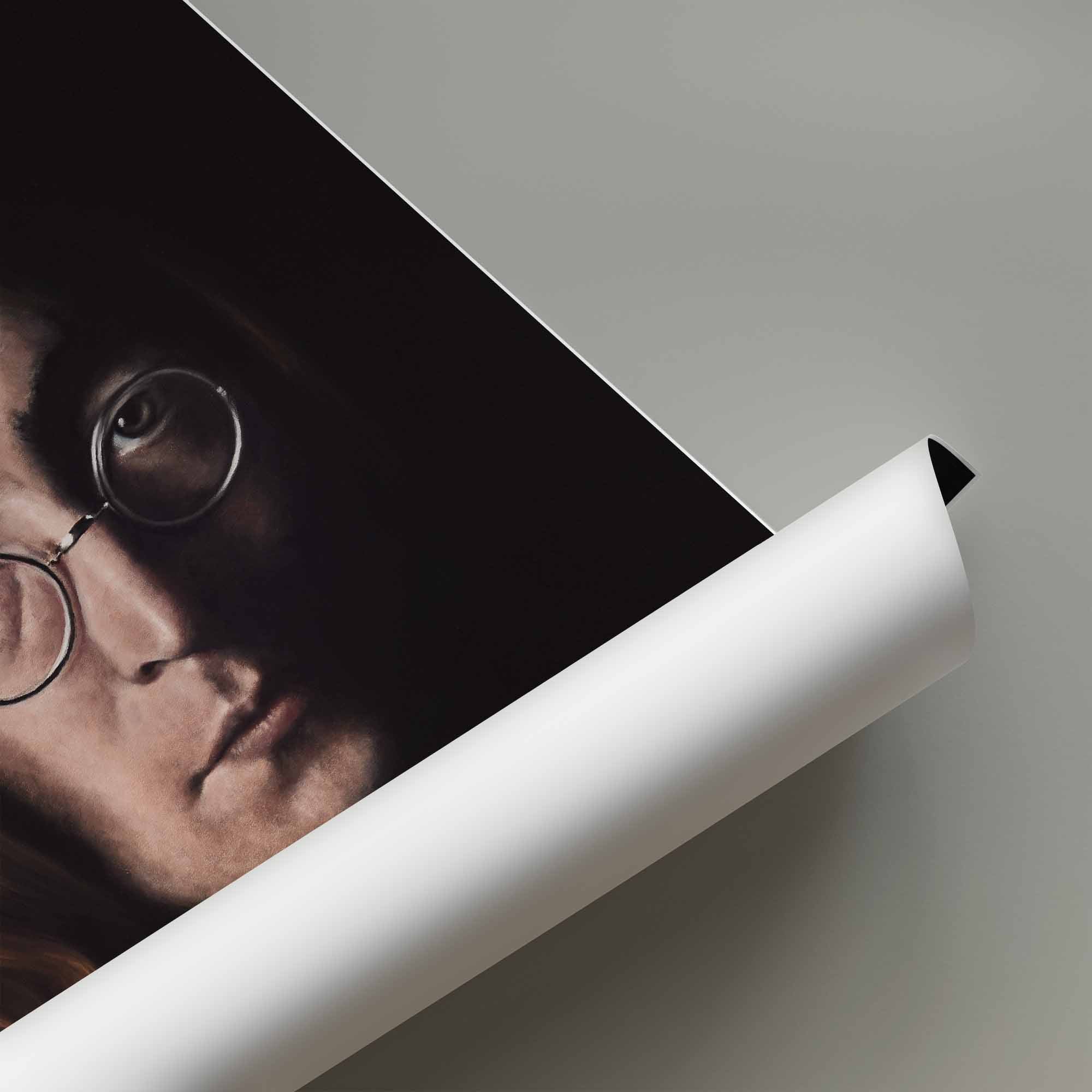 Rolled up poster of John Lennon on a grey background.