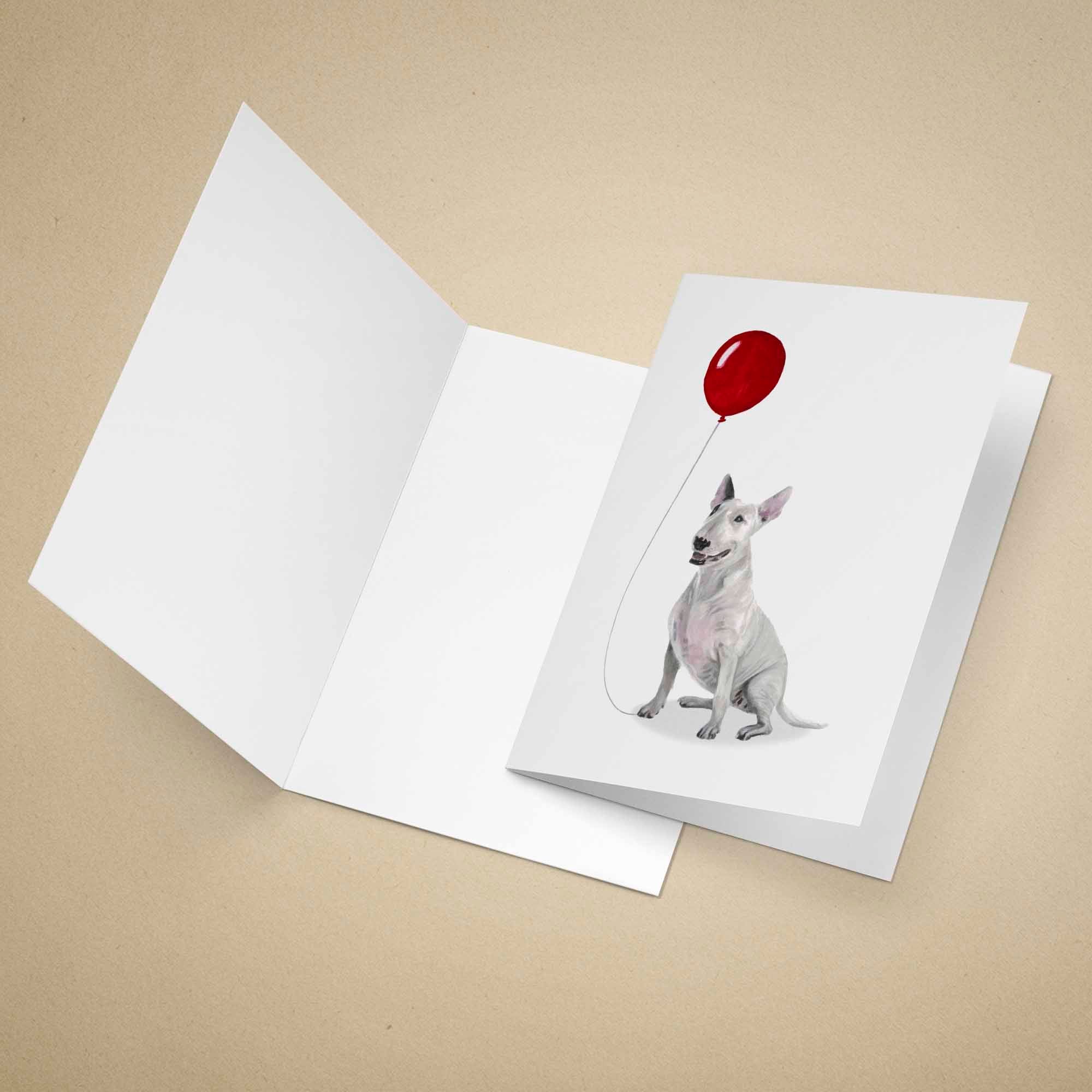 Greeting card with an English Bull Terrier holding a red balloon on a beige background