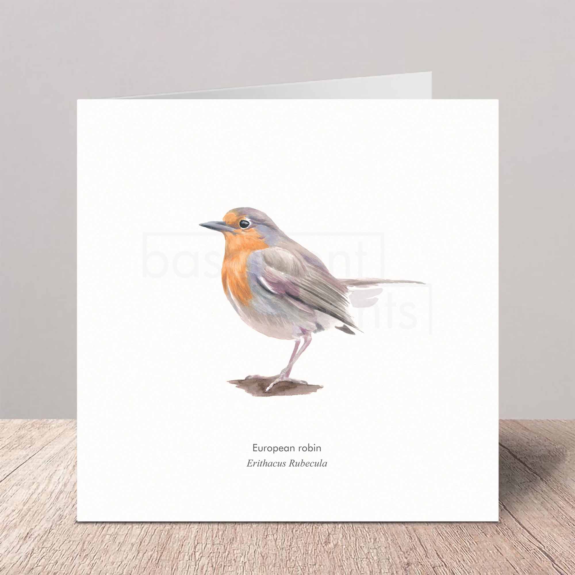 Greeting card with a watercolor illustration of a European robin on a wooden surface.