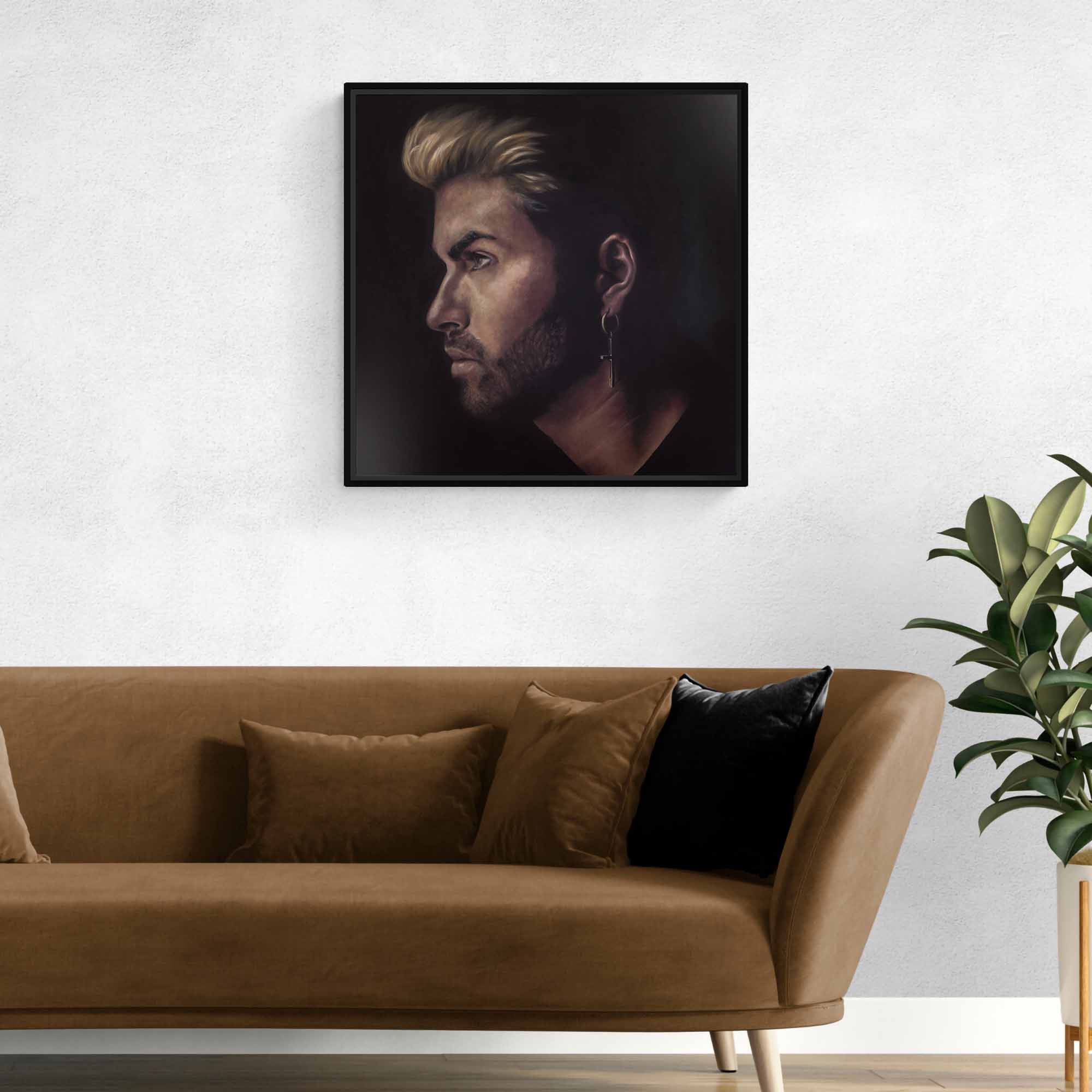Framed portrait of George Michael above a brown sofa with decorative pillows in a living room setting.