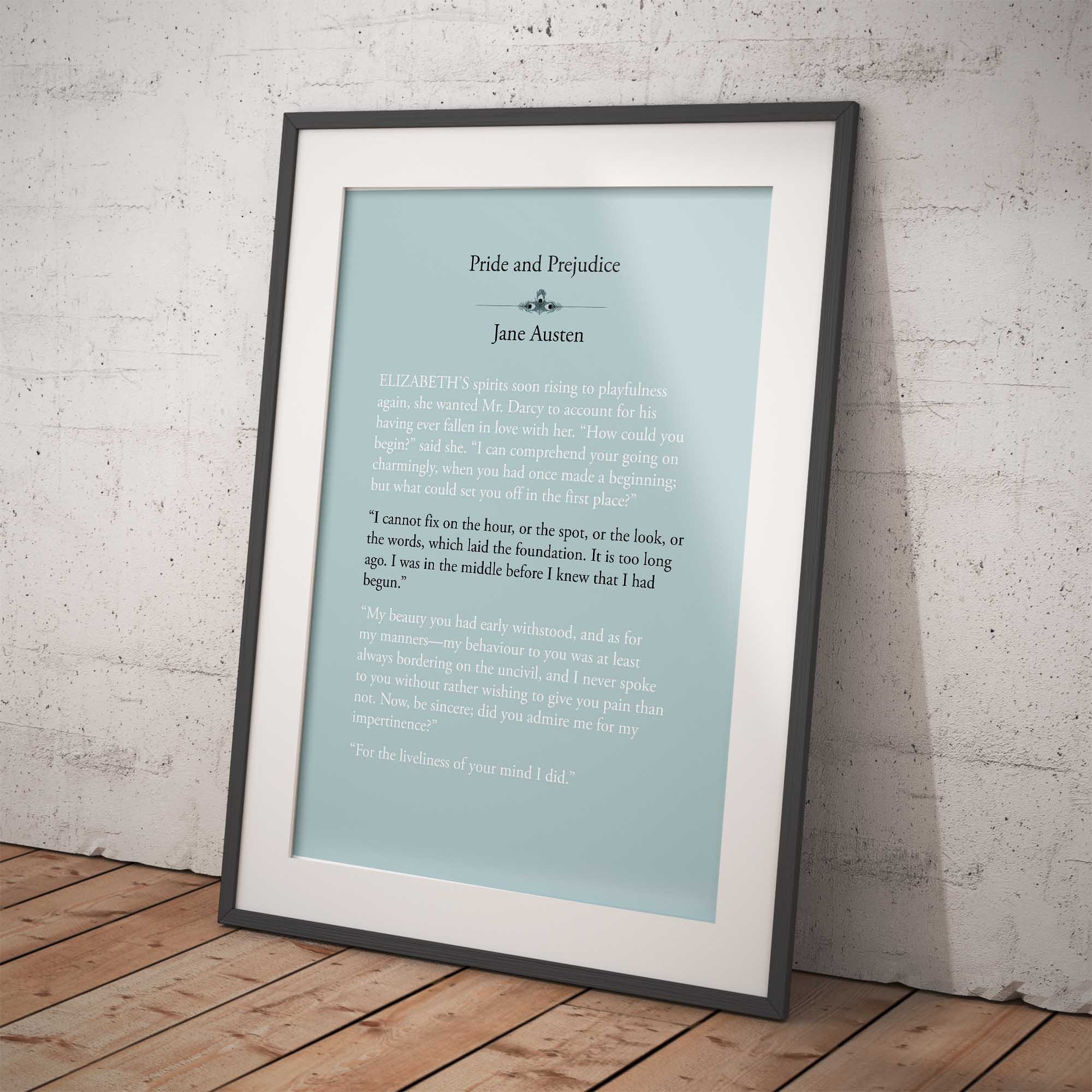 Framed print of 'Pride and Prejudice' by Jane Austen on a white brick wall.