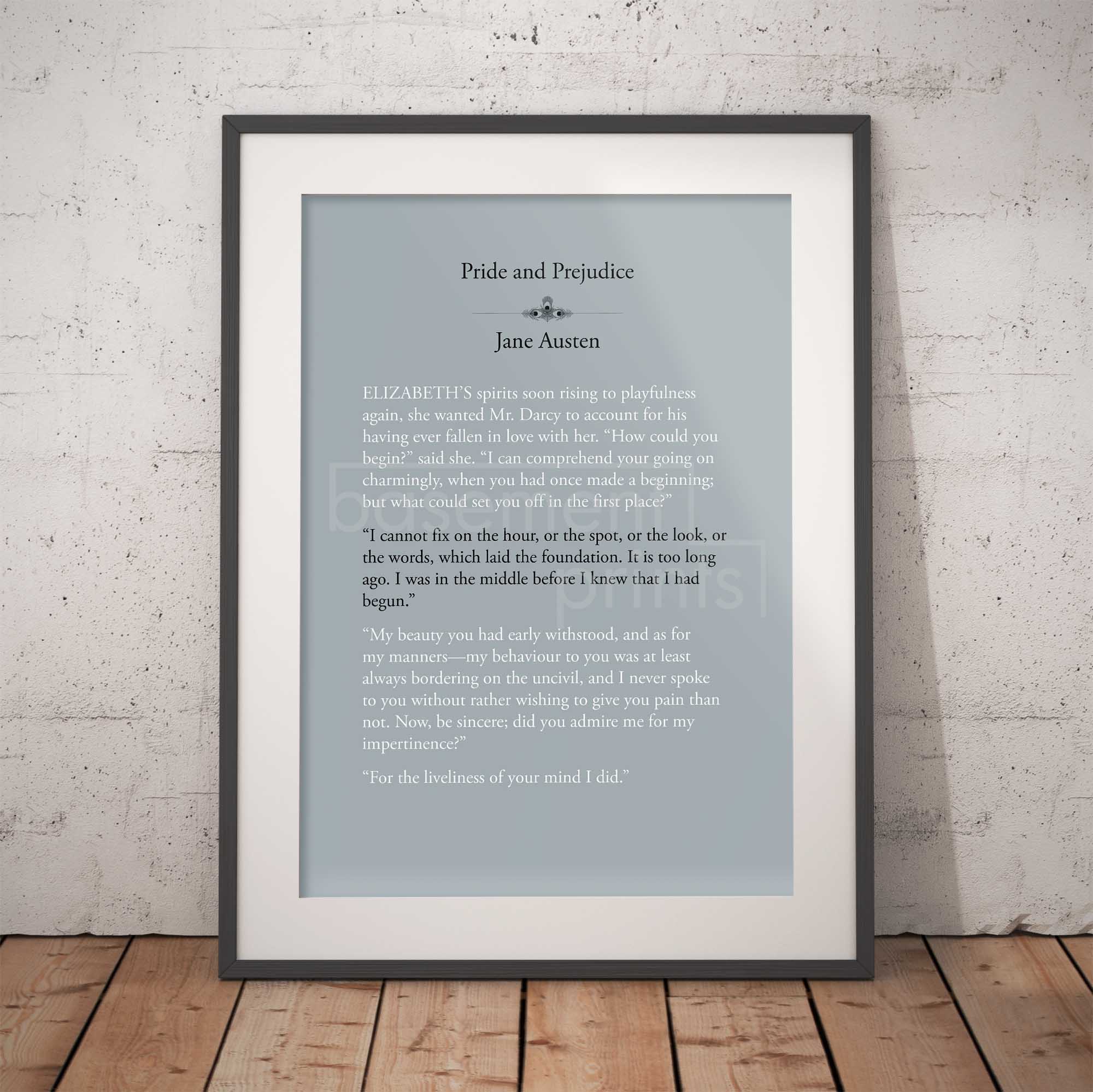 Framed text print of a quote from 'Pride and Prejudice' by Jane Austen on a light blue background, displayed against a white brick wall.