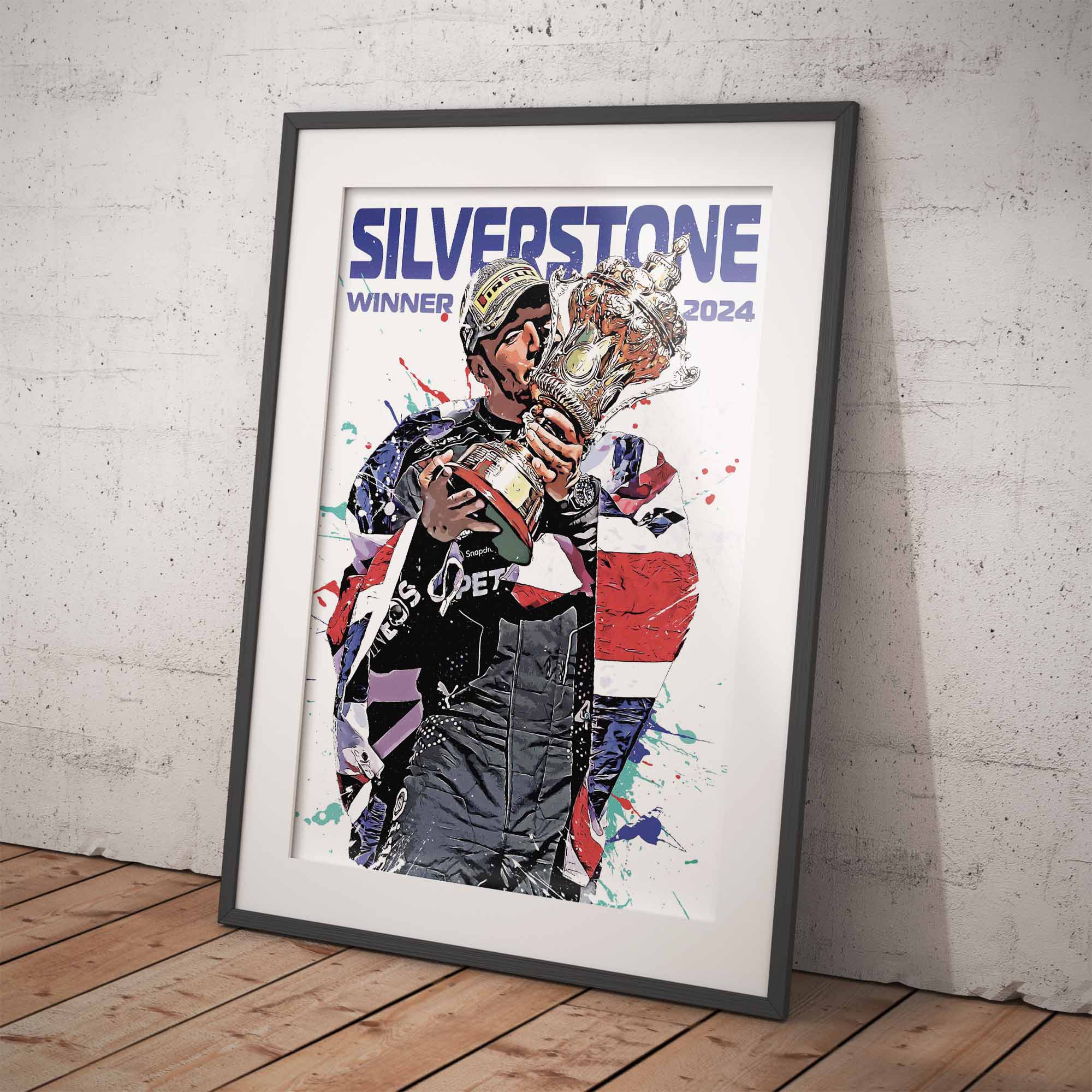 Framed poster of Lewis Hamilton holding a trophy with 'Silverstone Winner 2024' text on a white brick wall.