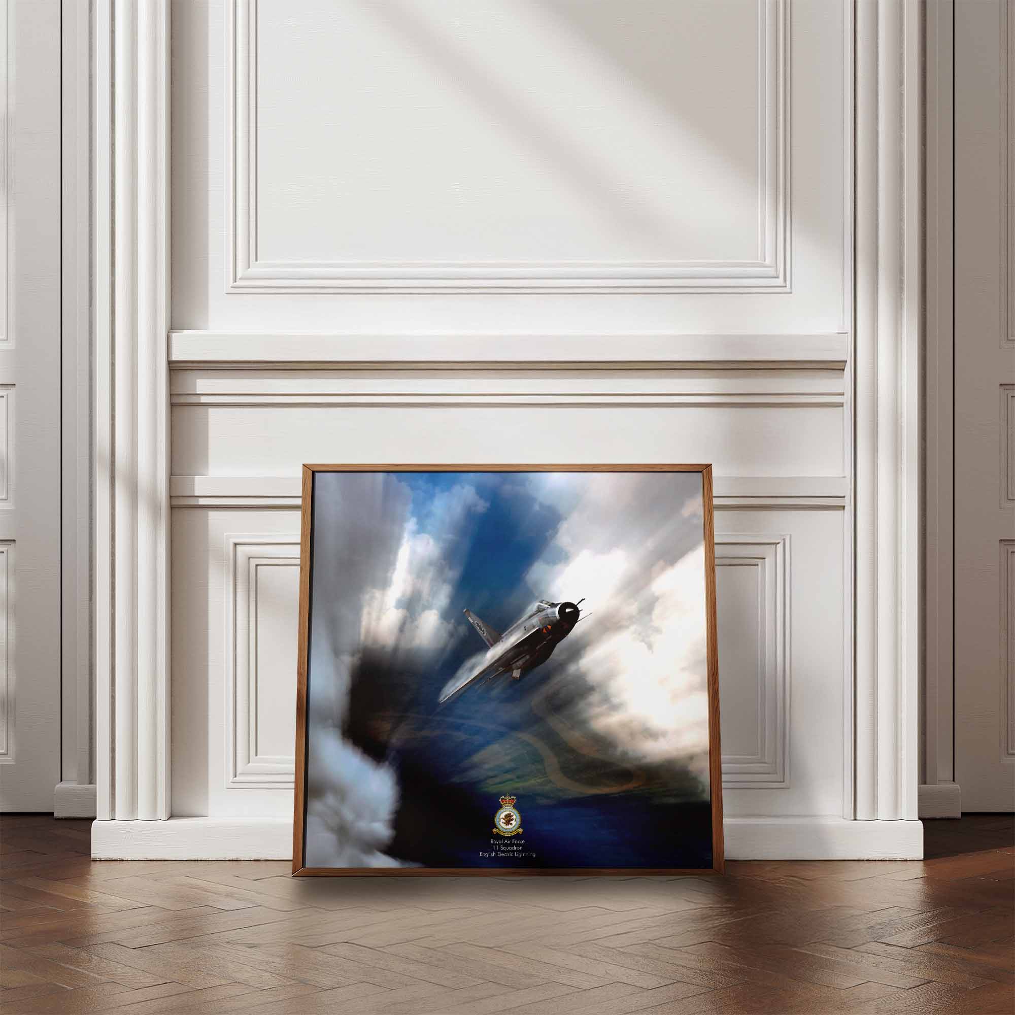 Framed artwork of a English Electric Lightning fighter jet against a cloudy sky on a wall with wooden flooring.