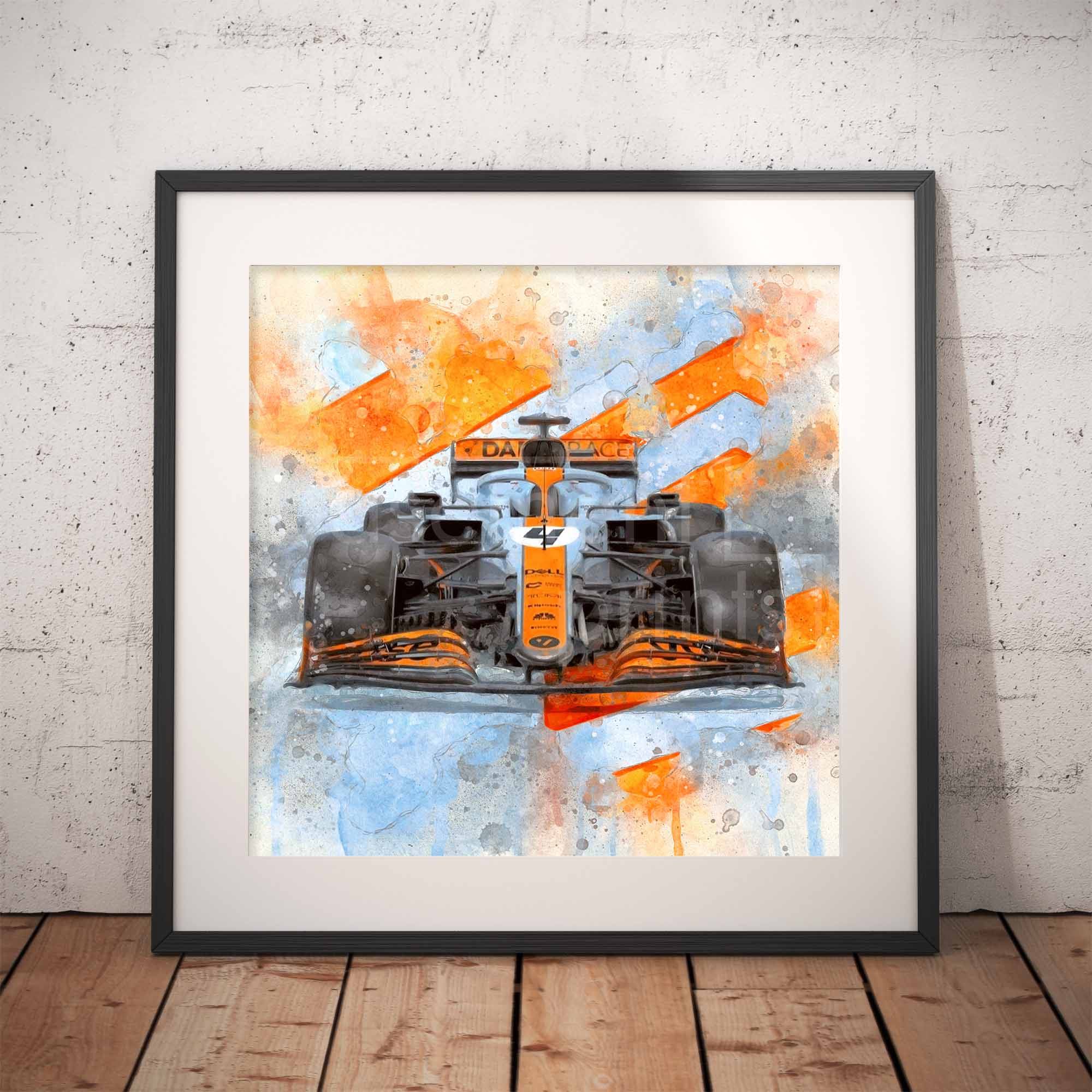Framed artwork of a McLaren F1 car in Gulf Livery with orange and blue design on a textured wall.