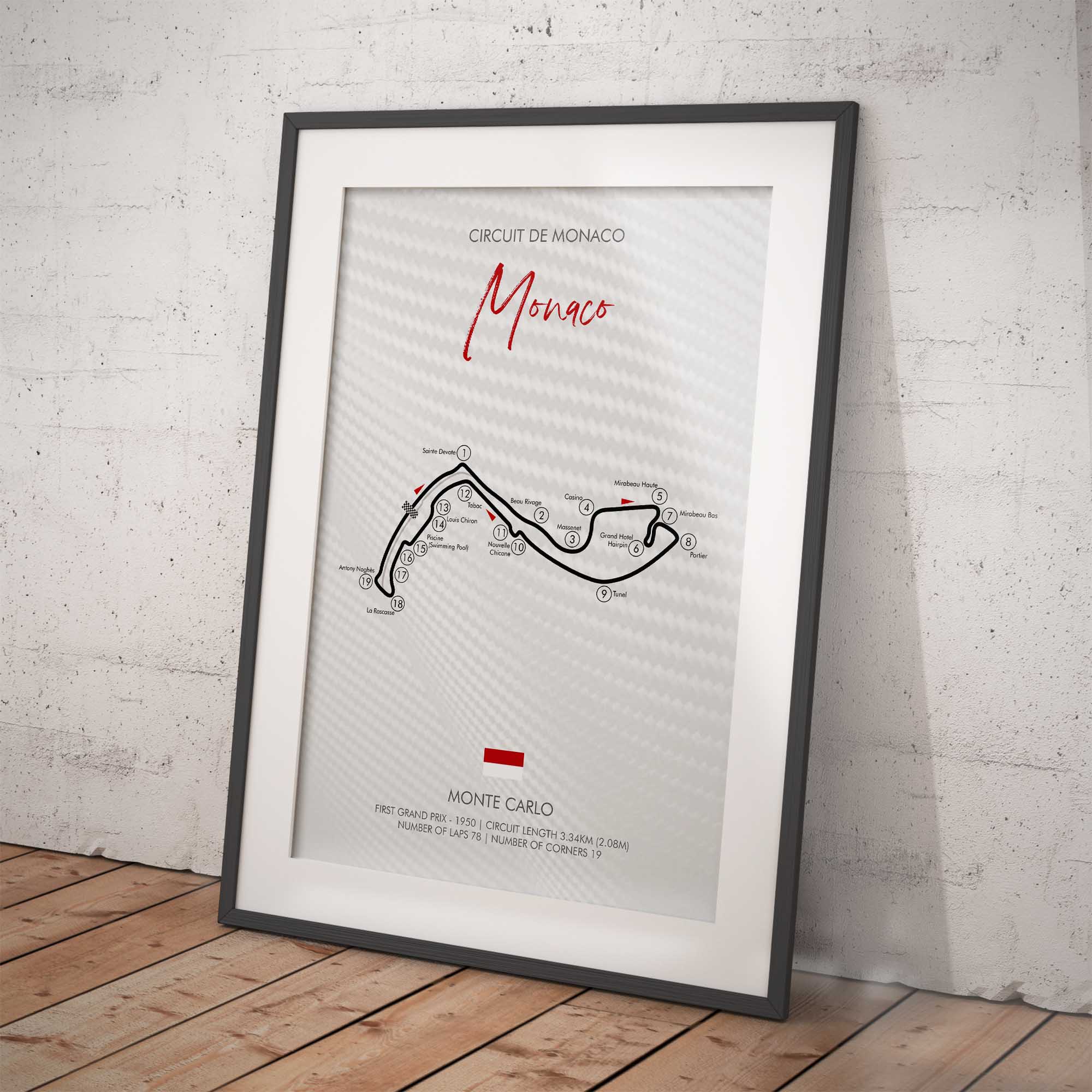 Framed poster of the Circuit de Monaco track layout on a white brick wall.