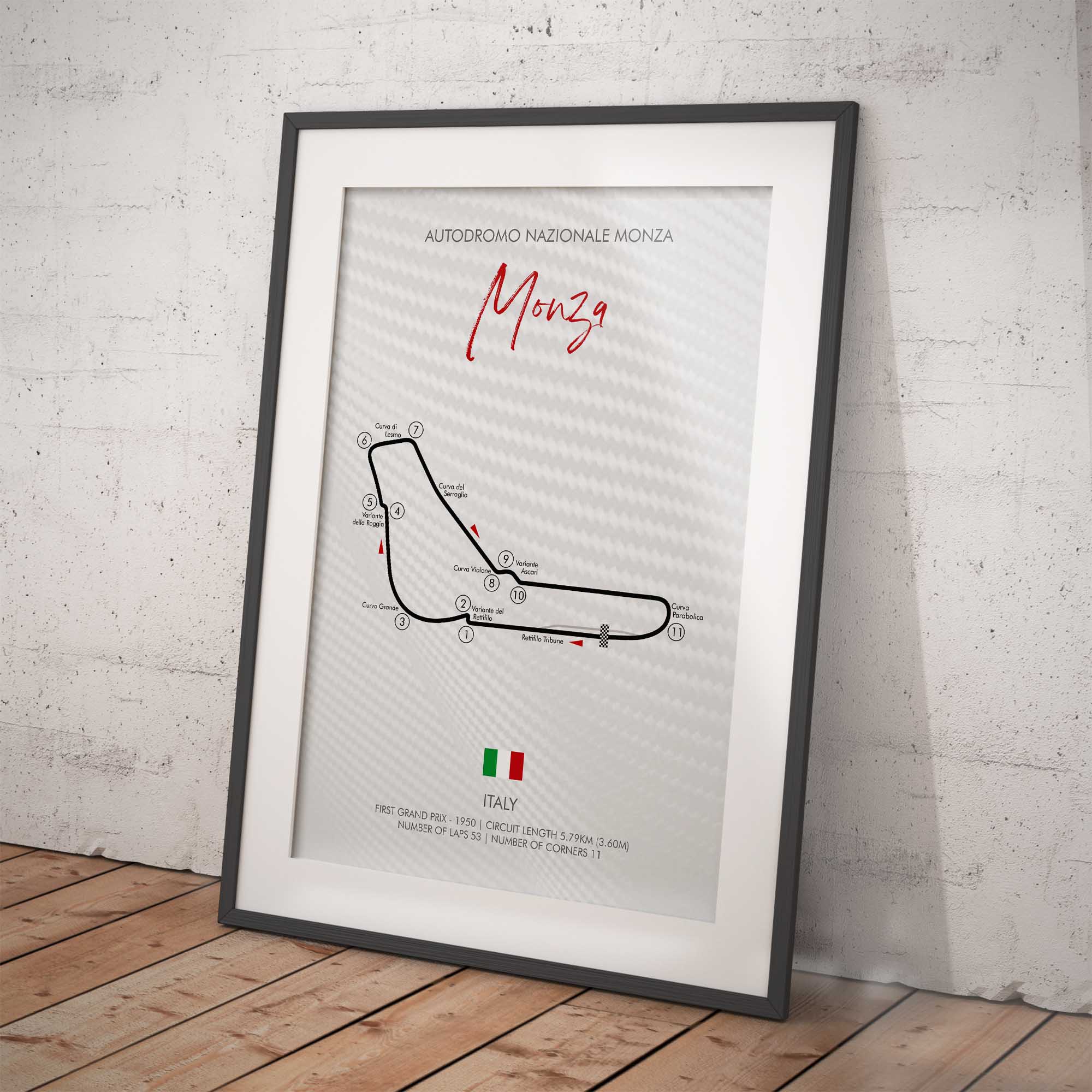 Framed poster of the Monza motor racing track layout on a white brick wall.