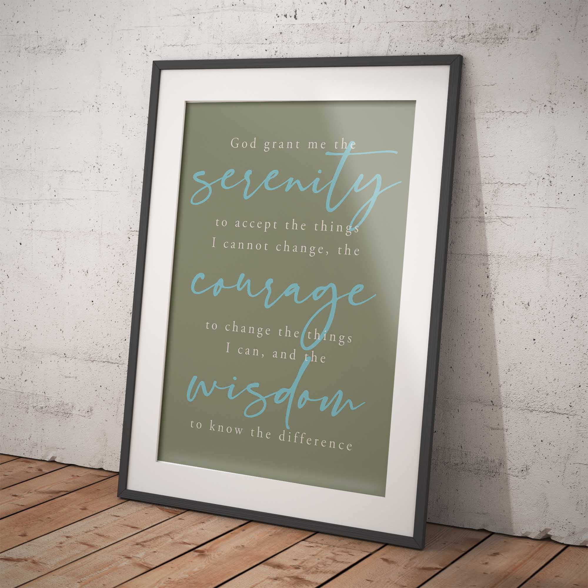 Framed print with Serenity Prayer on a wooden floor and white brick wall background
