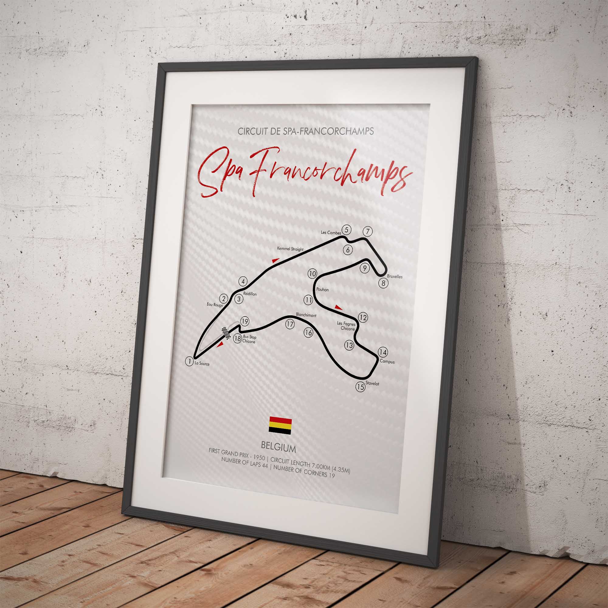 Framed poster of Spa Francorchamps circuit layout on a white brick wall.