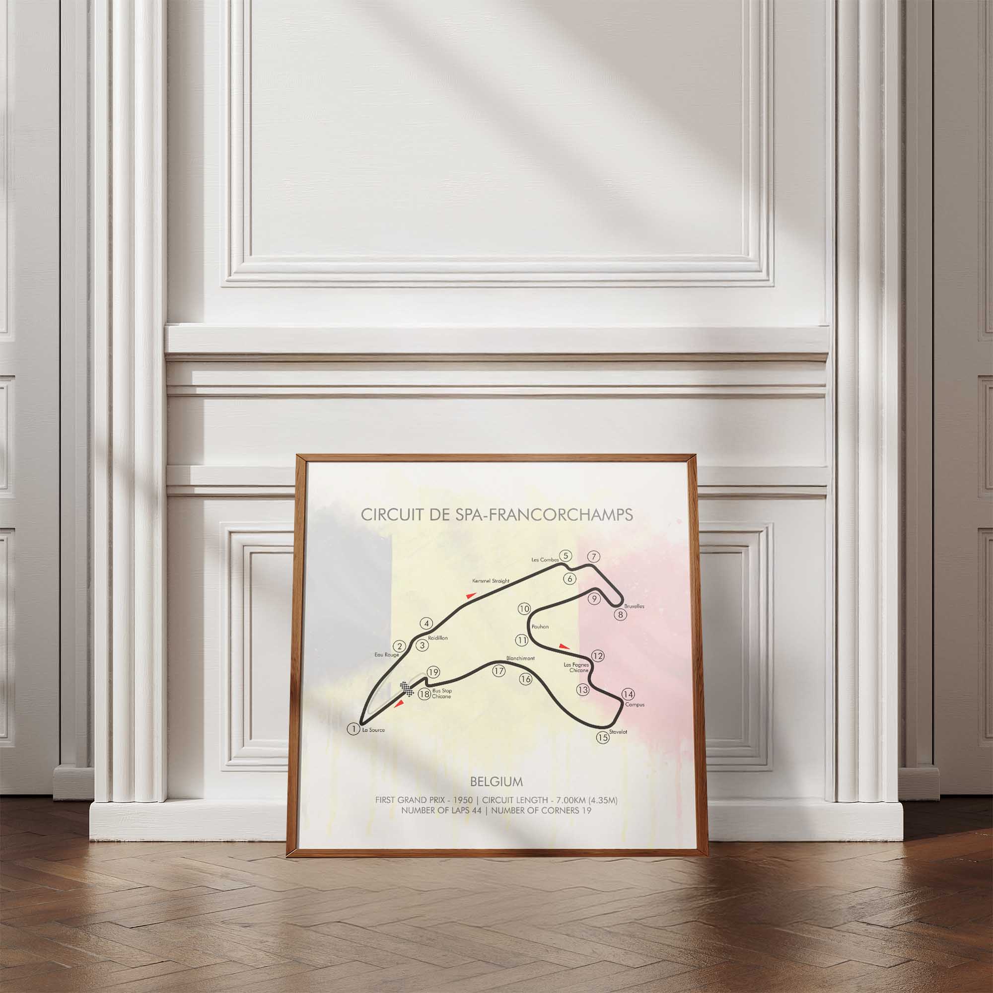 Framed map of Circuit de Spa-Francorchamps on a wall with wooden floor and white paneling.