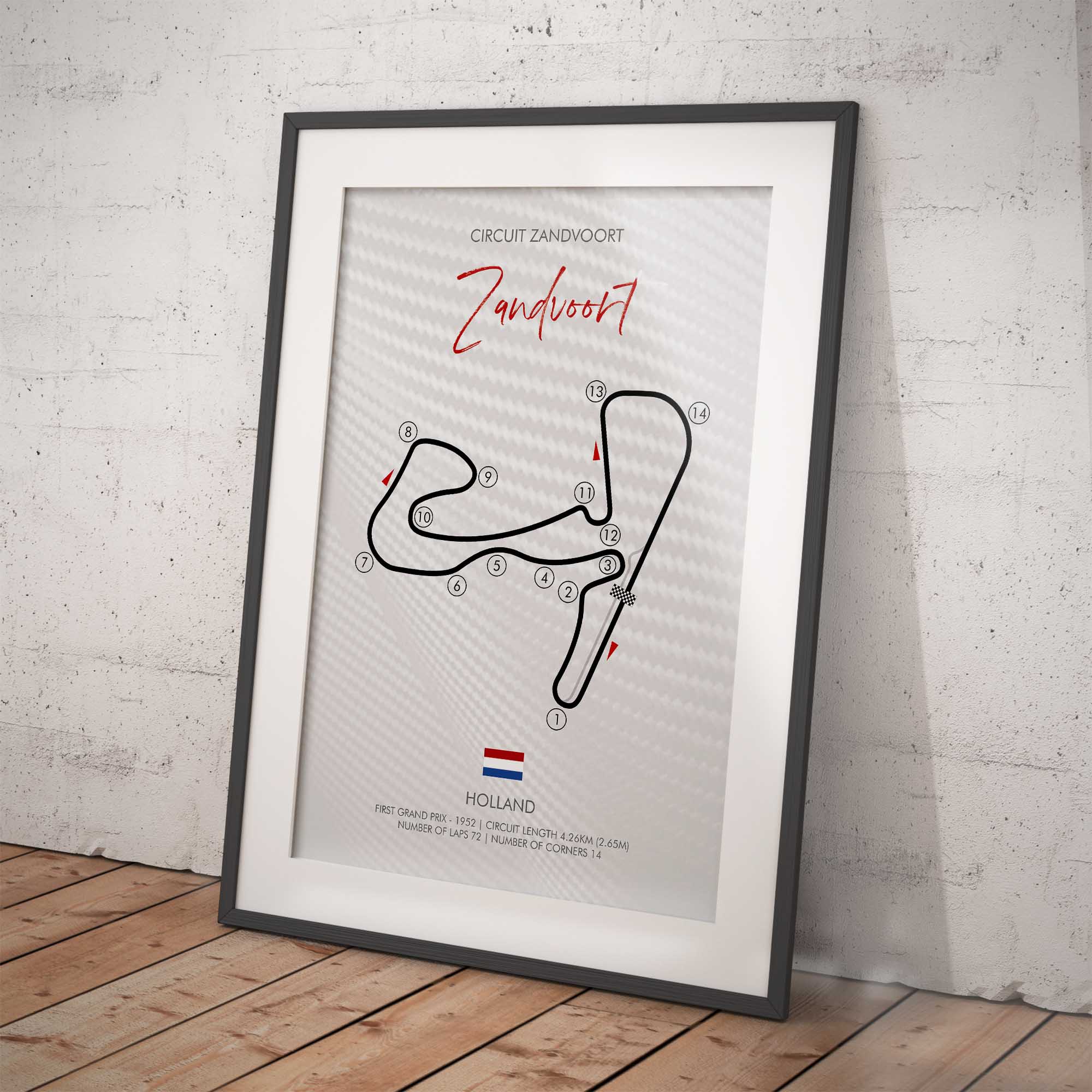 Framed track layout poster of Circuit Zandvoort on a white brick wall.