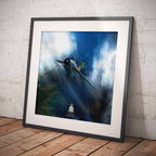 A framed art print of a military fighter jet flying through dramatic blue and white clouds, leaning against a white textured brick wall on a wooden floor.