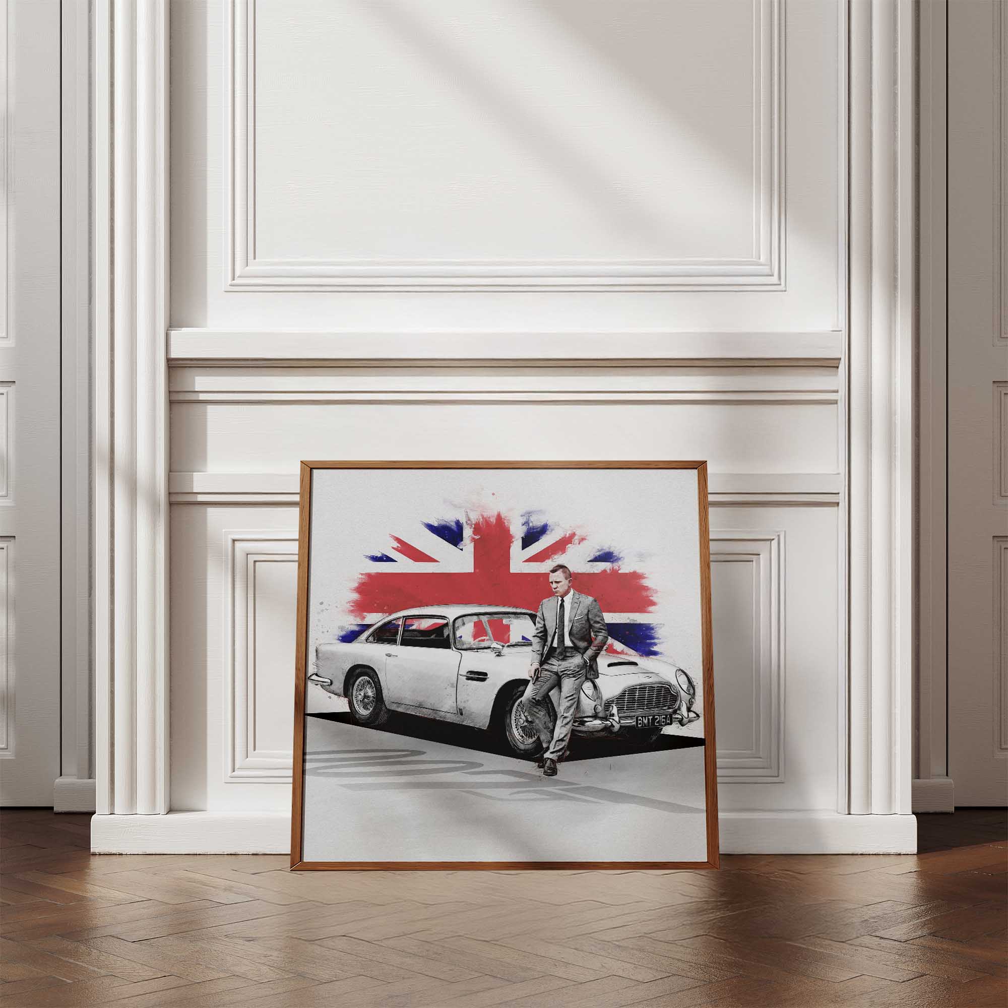 Framed artwork of a Daniel Craig leaning against a classic car with a Union Jack design on a white wall.
