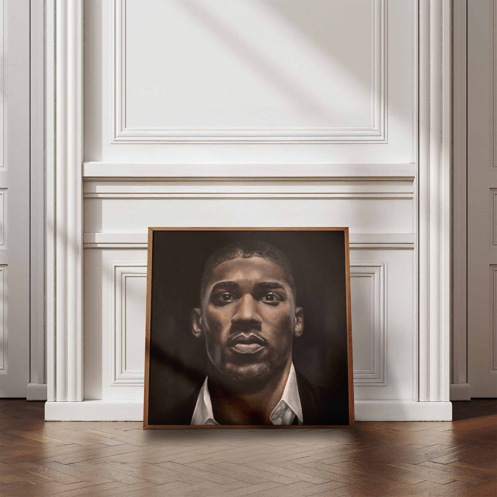 Framed portrait of Anthony Joshua on a wall in a room with wooden flooring and white walls.
