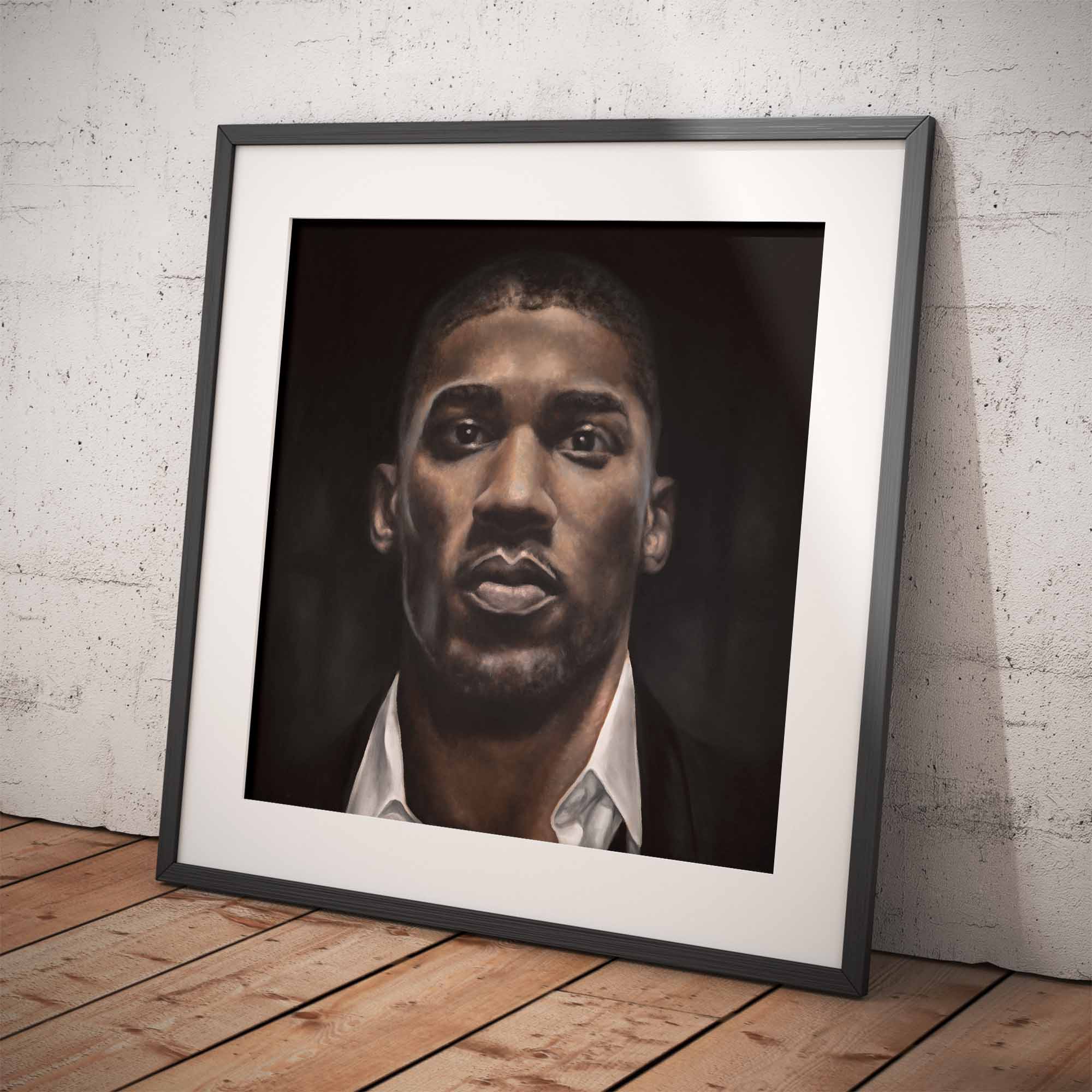 Framed oil painting of the boxer Anthony Joshua leaning against a white brick wall and wooden floor.