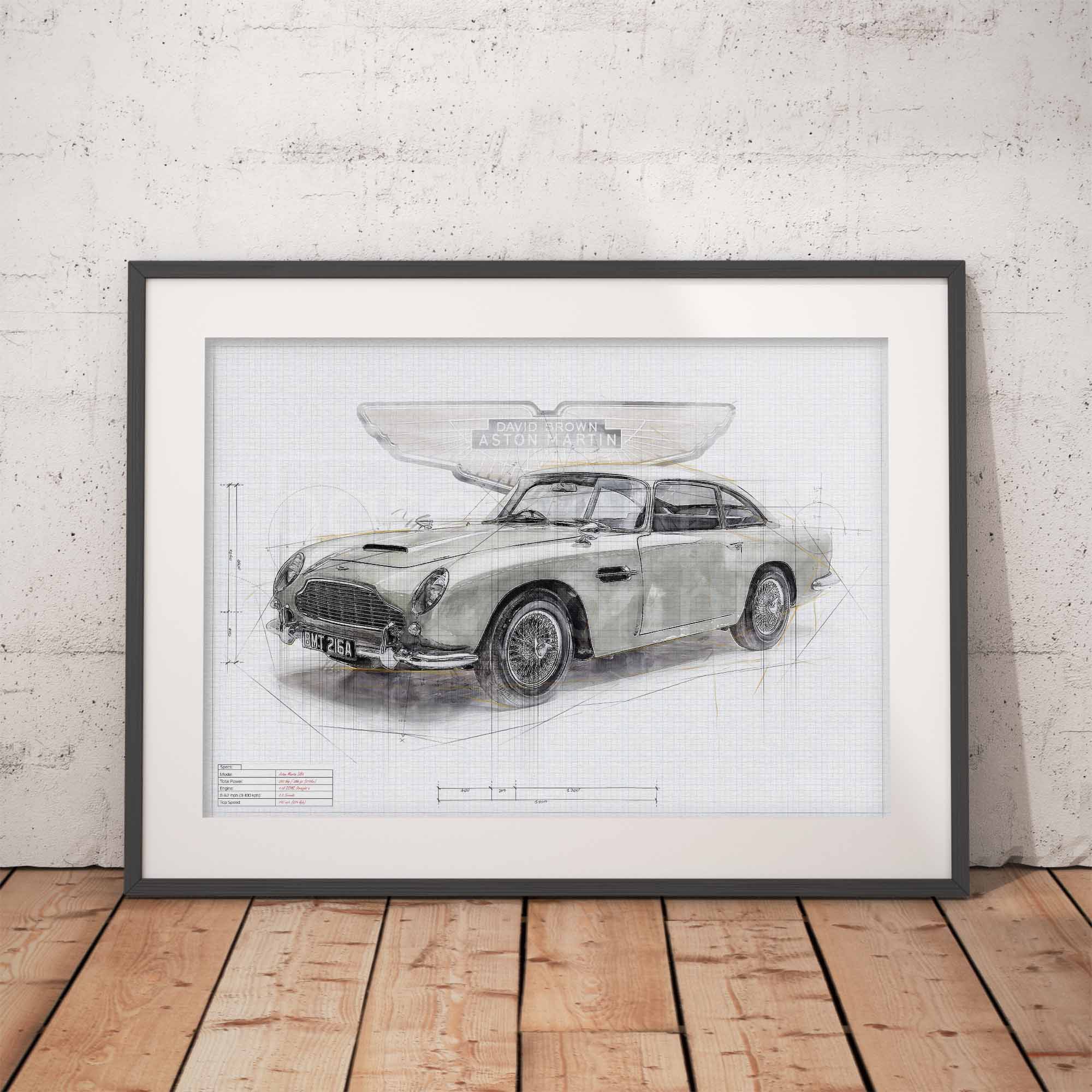 Framed blueprint of an Aston Martin DBS on a wooden floor with a white brick wall background