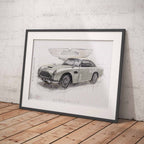 Framed artowrk of James Bonds Aston Martin DB5 car blueprint on a wooden floor against a white brick wall.