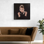Framed portrait of Audrey Hepburn on a wall above a brown sofa with decorative pillows.