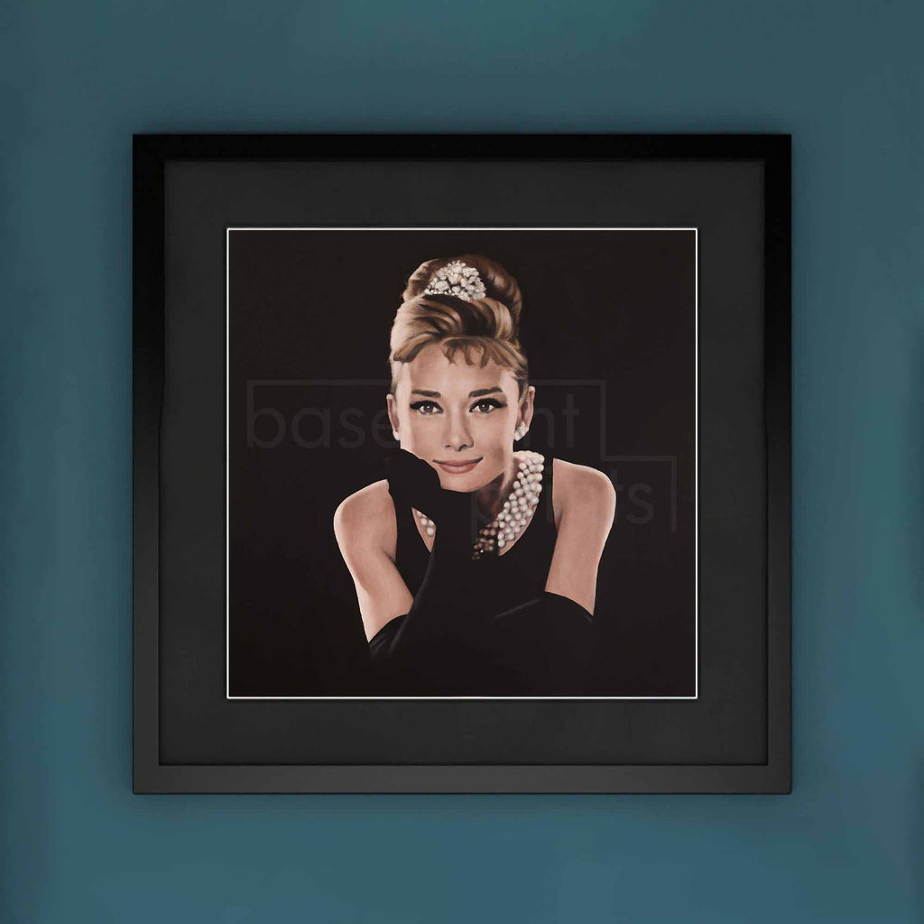 Framed artwork of a stylized portrait of Audrey Hepburn with a blue background
