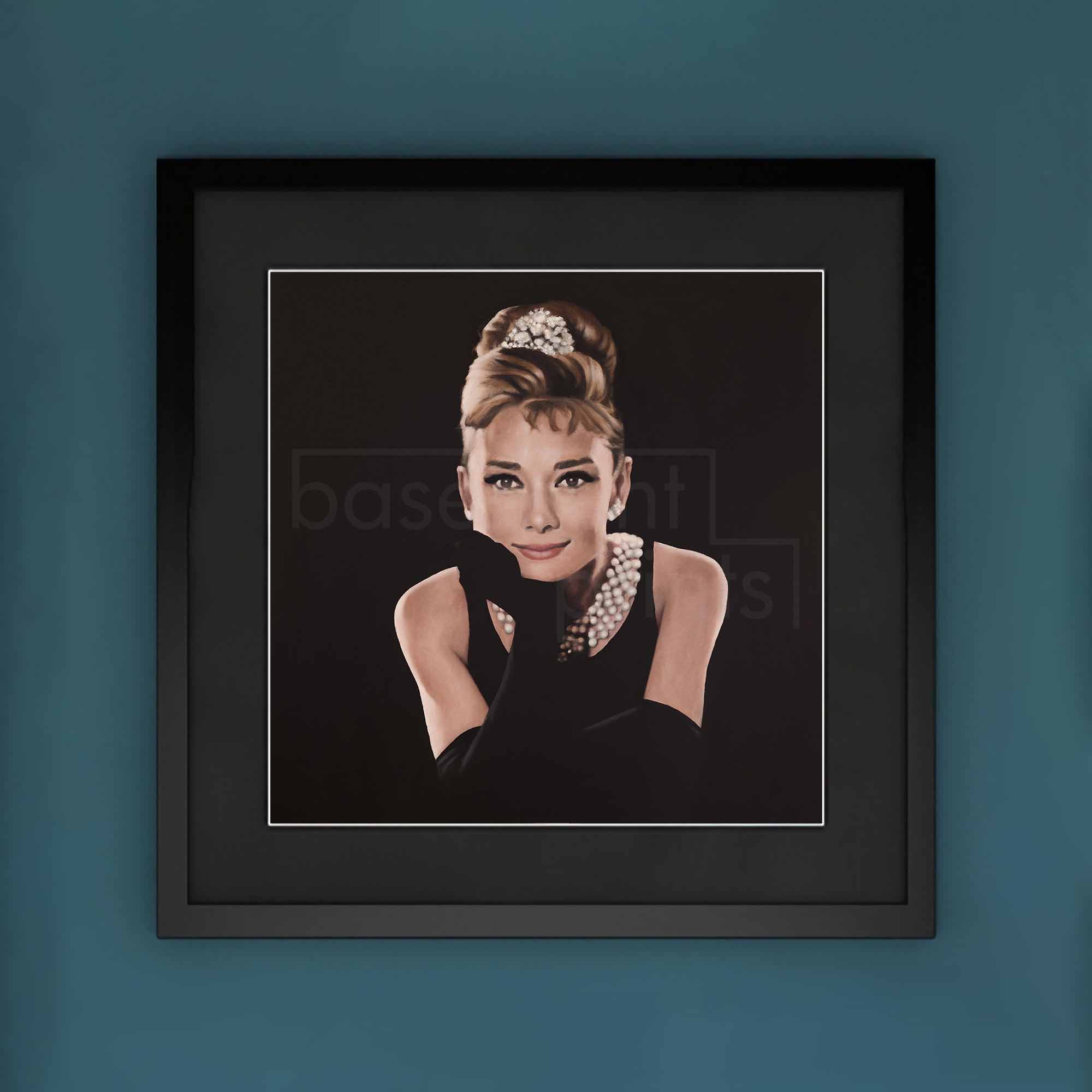 Framed artwork of a stylized portrait of Audrey Hepburn with a blue background