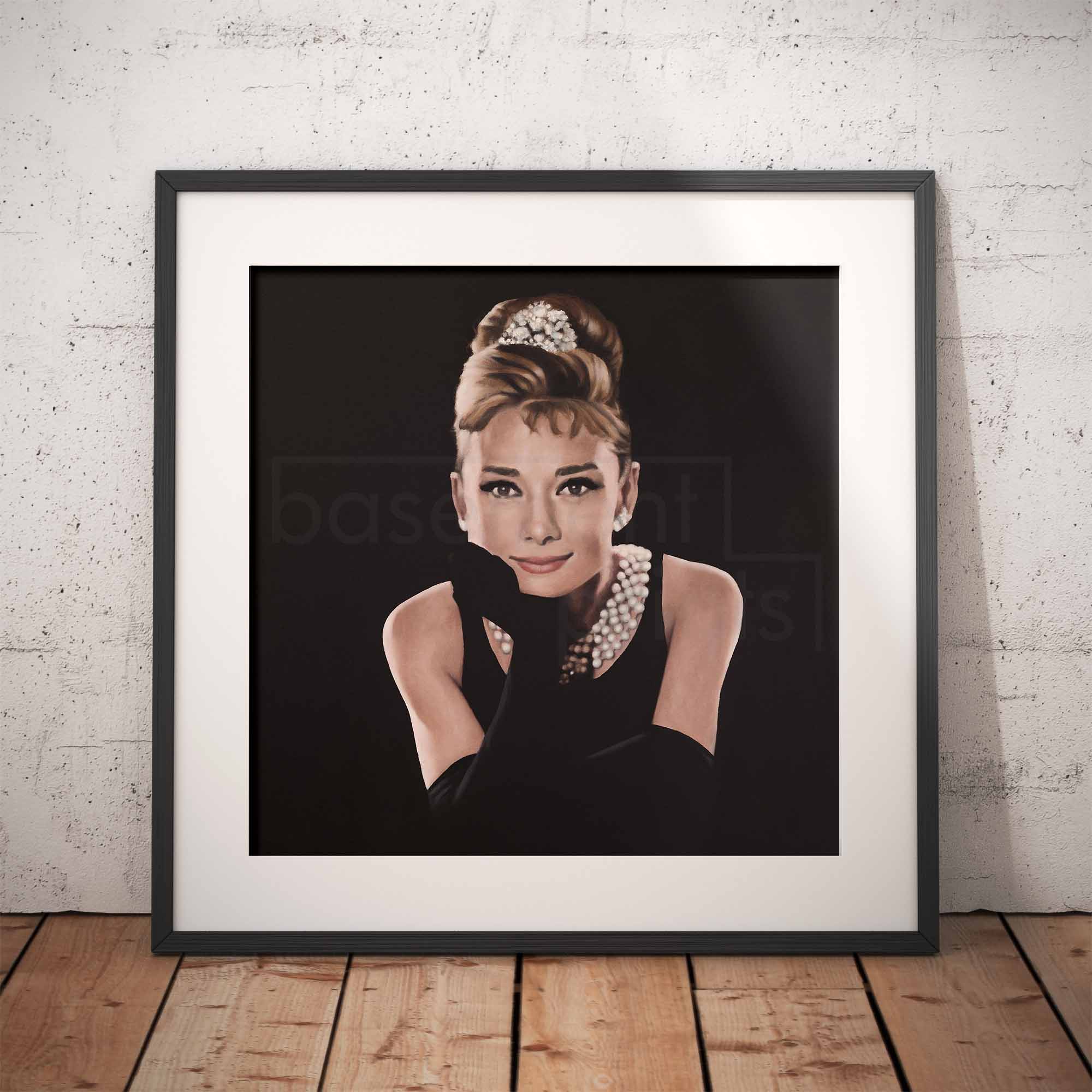 Framed artwork of a stylized portrait of Audrey Hepburn with a black background