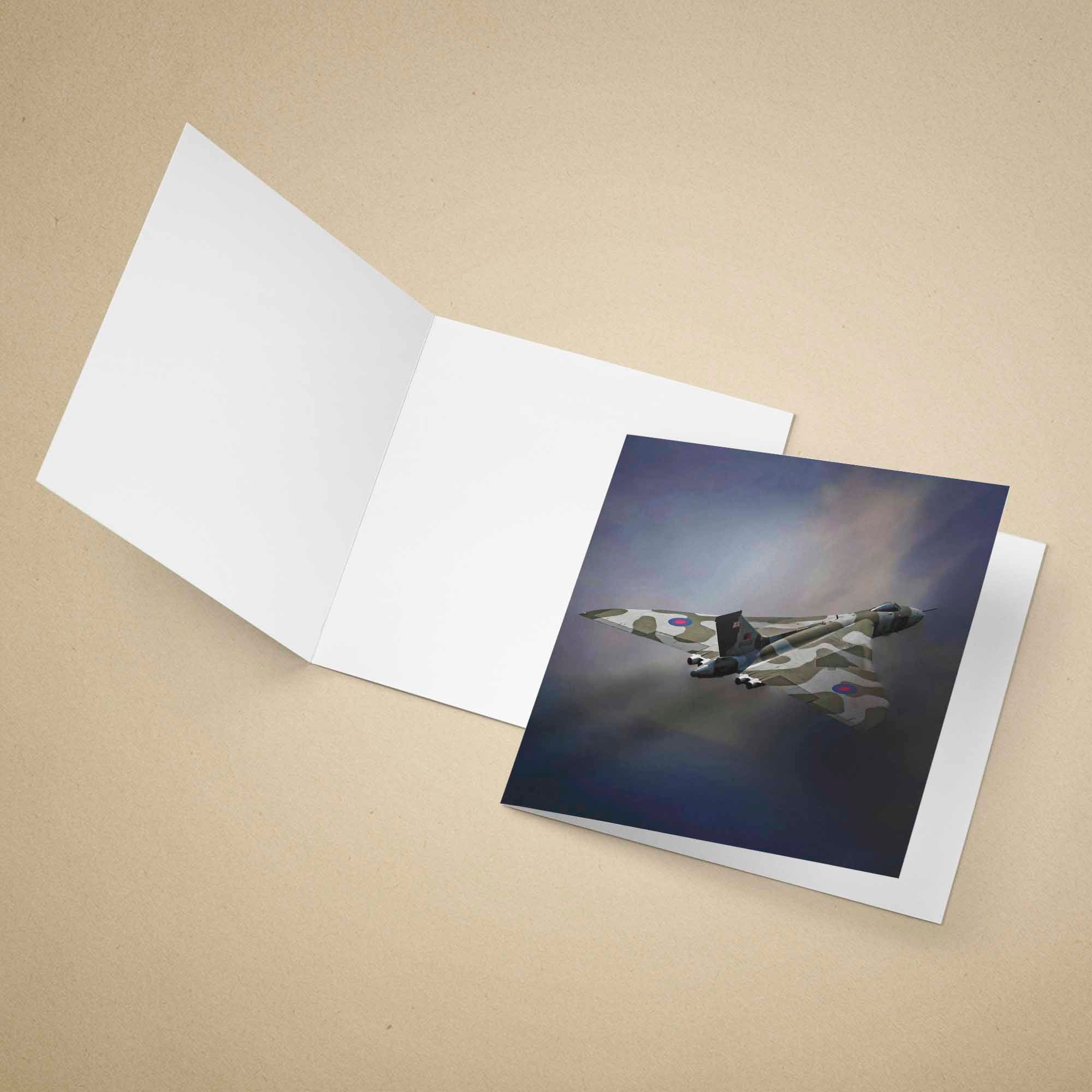 Greeting card with a Vulcan Bomber aircraft on a dark background, placed inside an open white envelope on a beige surface.