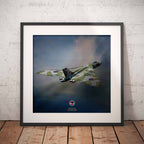 Framed artwork of a Vulcan Bomber against a blue sky on a wooden floor with white brick wall background