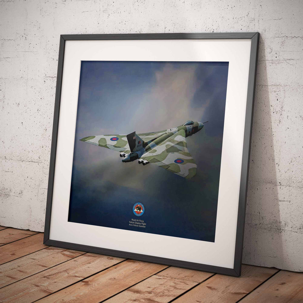 Framed artwork of an Avro Vulcan Bomber against a blue sky with clouds on a wooden floor.