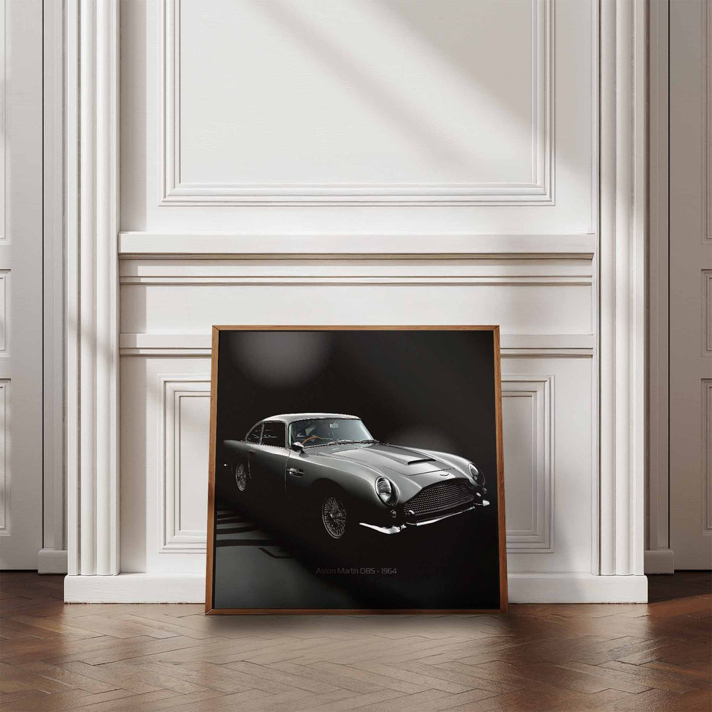 Framed artwork of James Bonds Aston Martin DB5 against a wall in a room with wooden flooring and white walls.