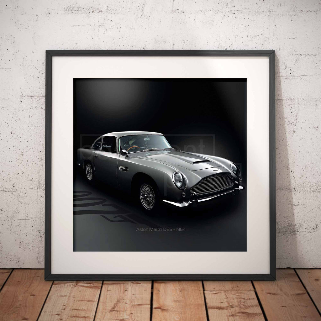 Framed artwork of an Aston Martin DB5 car on a dark background with '007' branding, displayed against a textured wall.