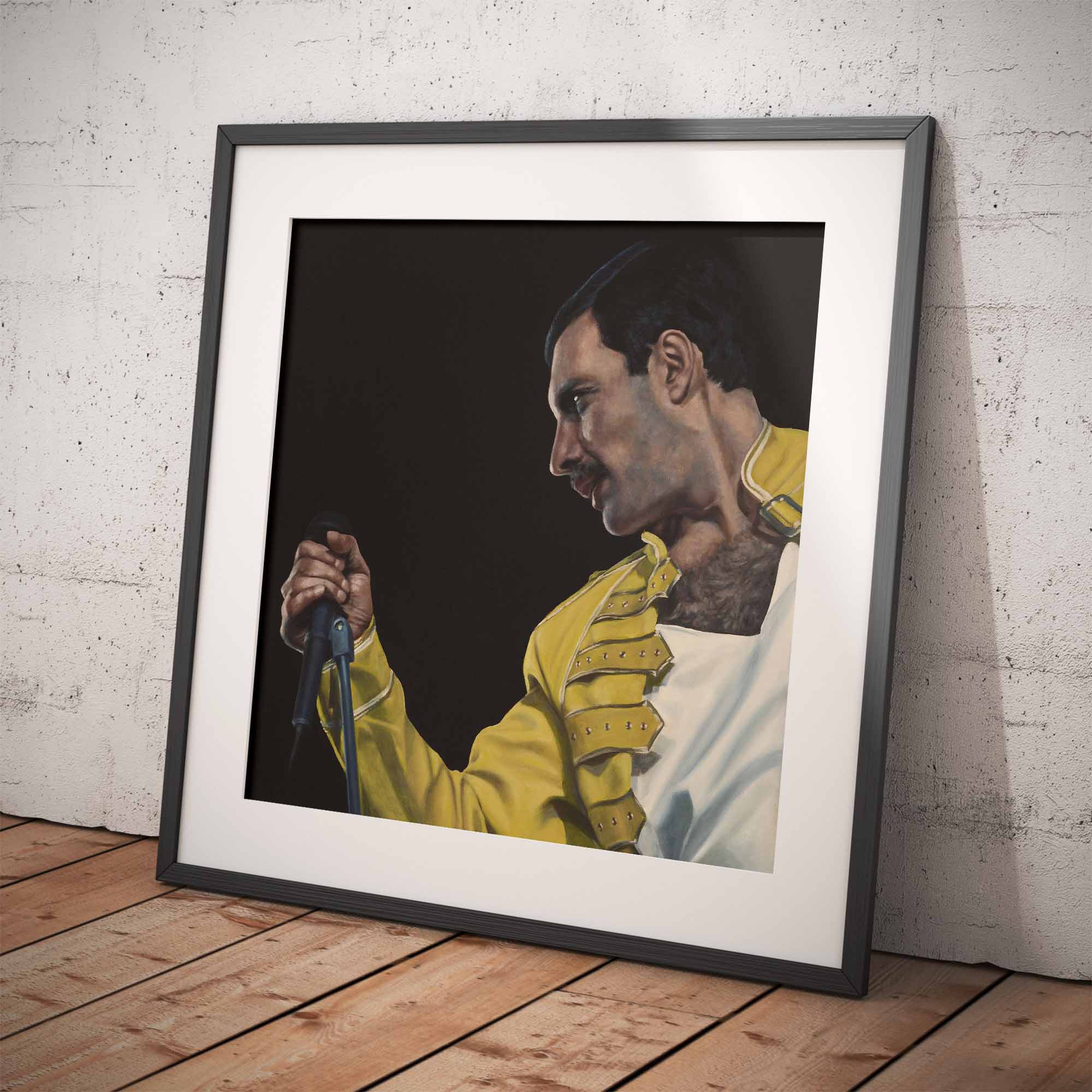 Framed portrait of Freddie Mercury in a yellow jacket against a dark background, leaning against a textured white wall.