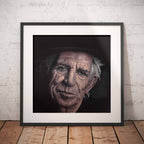 Framed portrait of Keith Richards against a white brick wall.