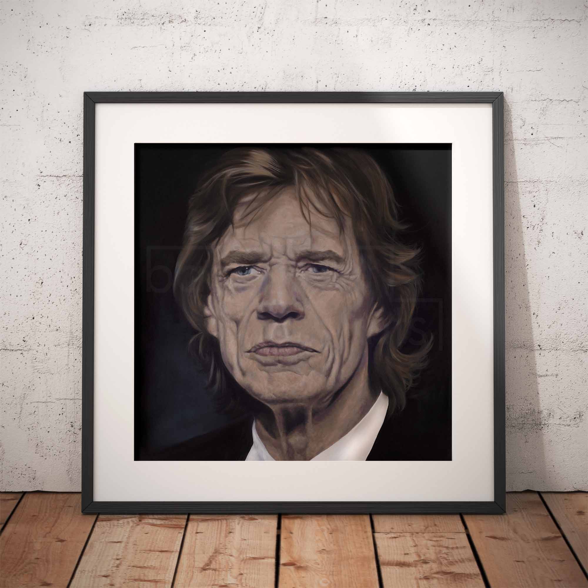 Framed portrait of Mick Jagger on a wooden floor with a white brick wall background