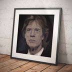 Framed portrait of Mick Jagger on a wooden floor with a white brick wall background