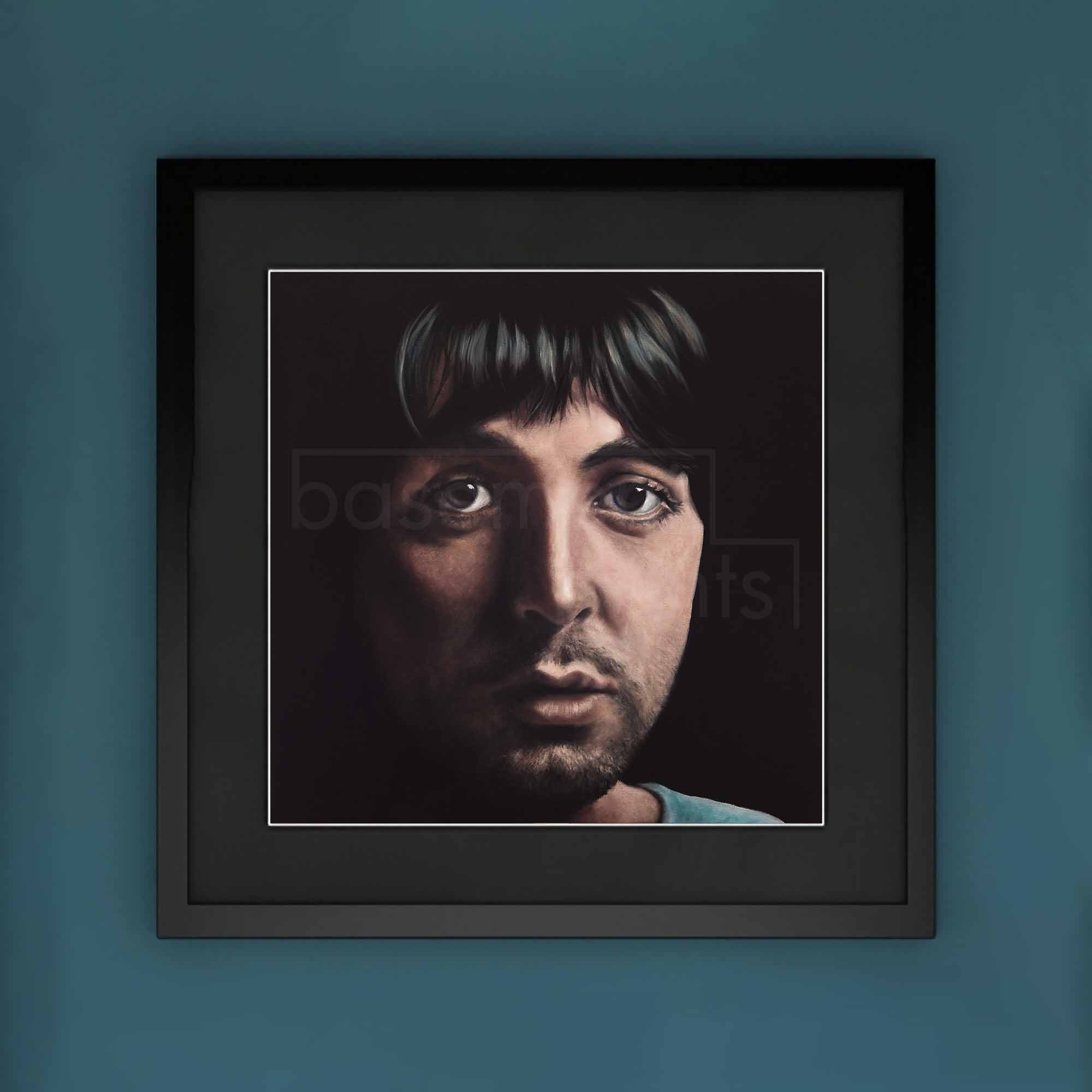 Framed portrait of Paul McCartney on a blue wall