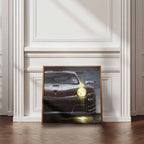 Framed artwork of a Porsche 911 Supercup car on a wall in a room with wooden flooring and white walls.