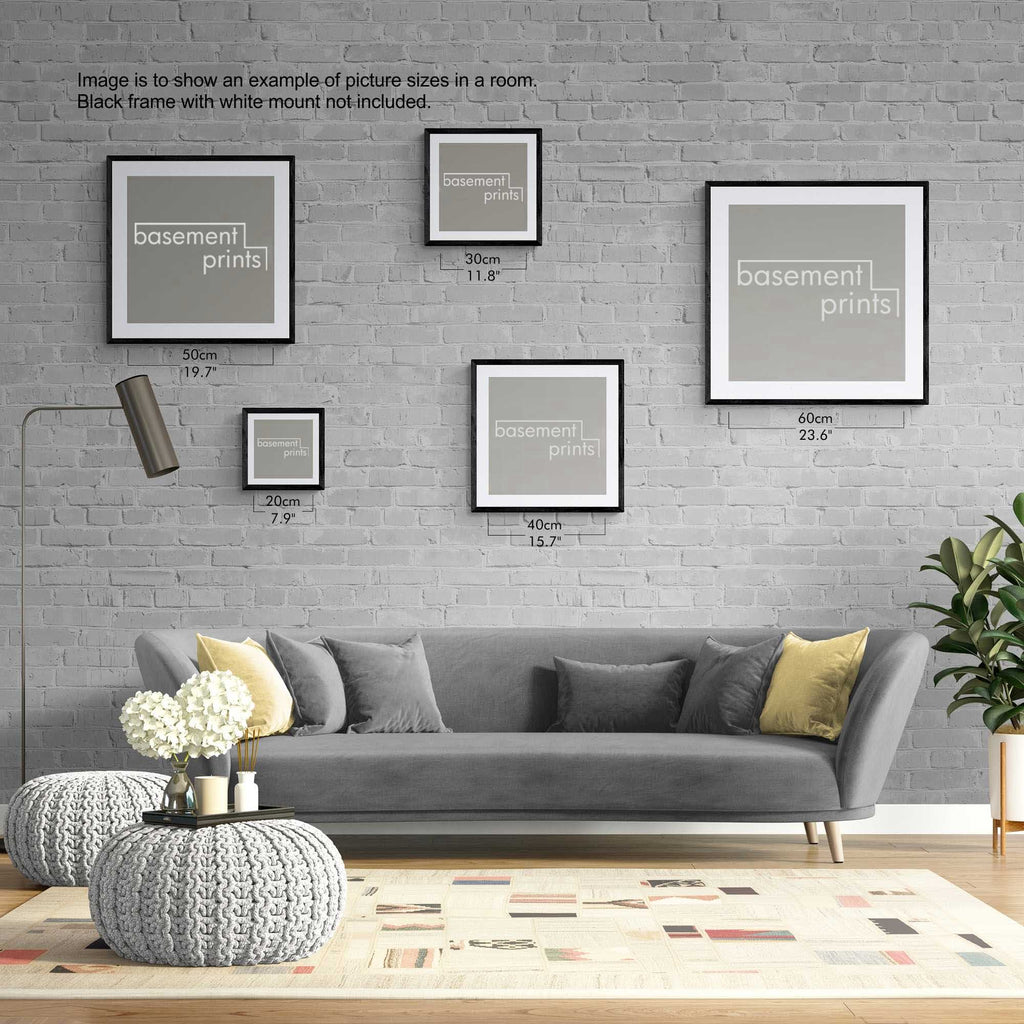 Living room with gray sofa, decorative yellow pillows, and square framed prints on a brick wall.