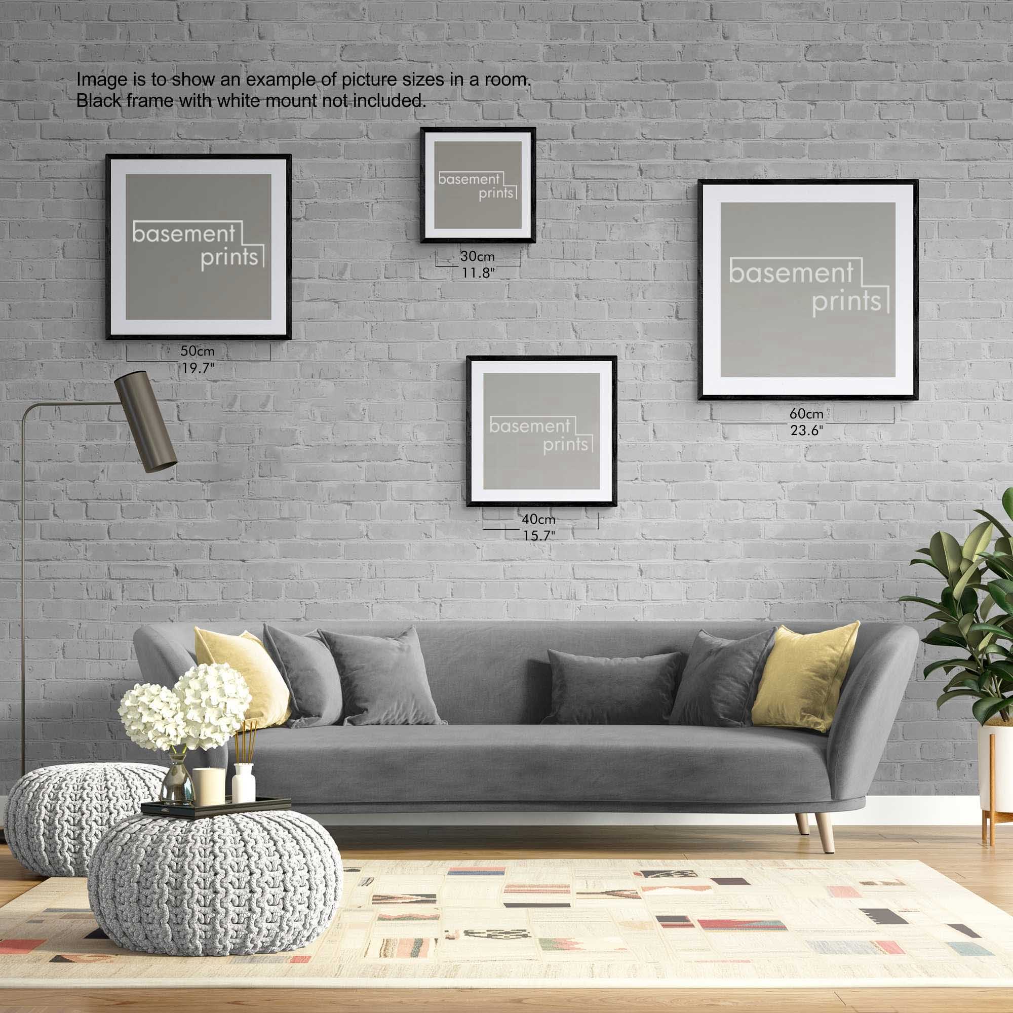 Living room with gray sofa, decorative pillows, and framed square prints on a gray brick wall.