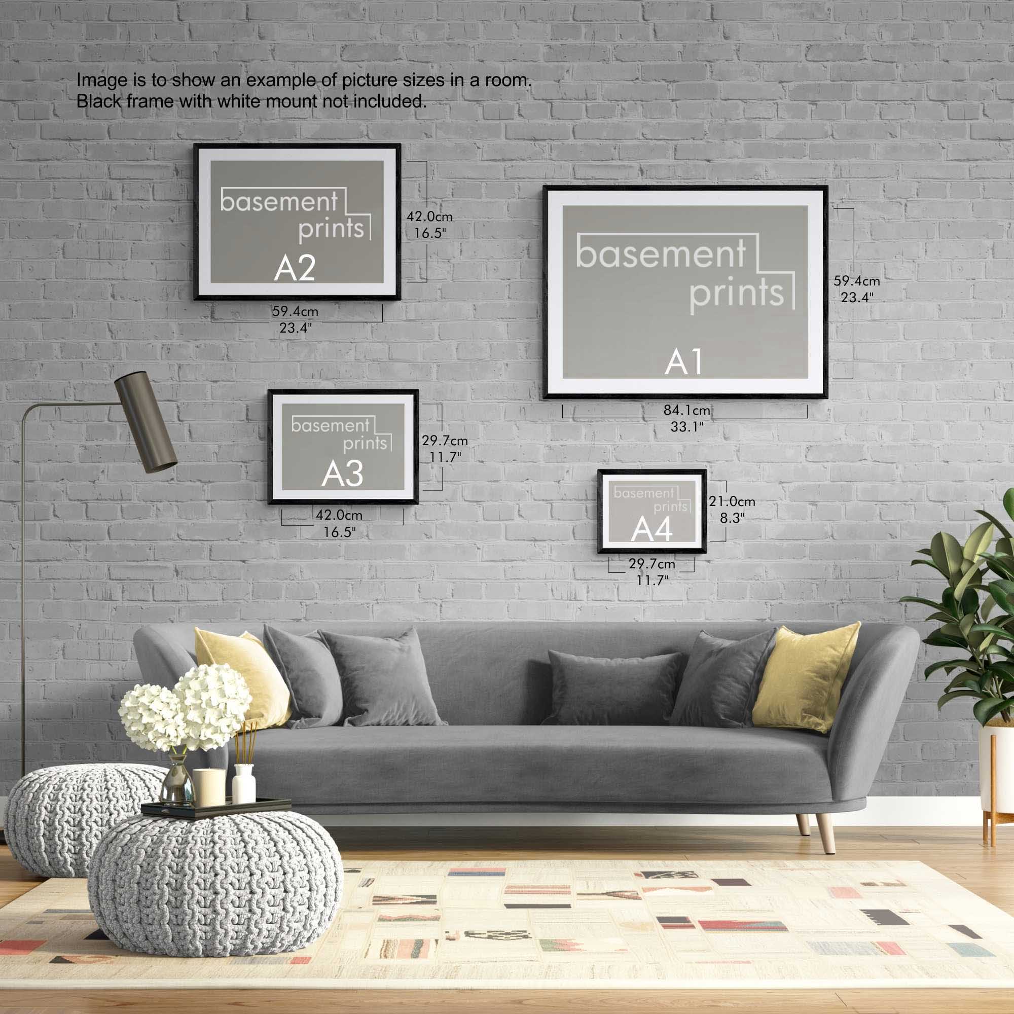 Living room with gray sofa, decorative yellow pillows, and landscape framed prints on a brick wall.