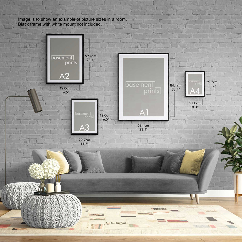 Living room with gray sofa, decorative yellow pillows, and landscape framed prints on a brick wall.