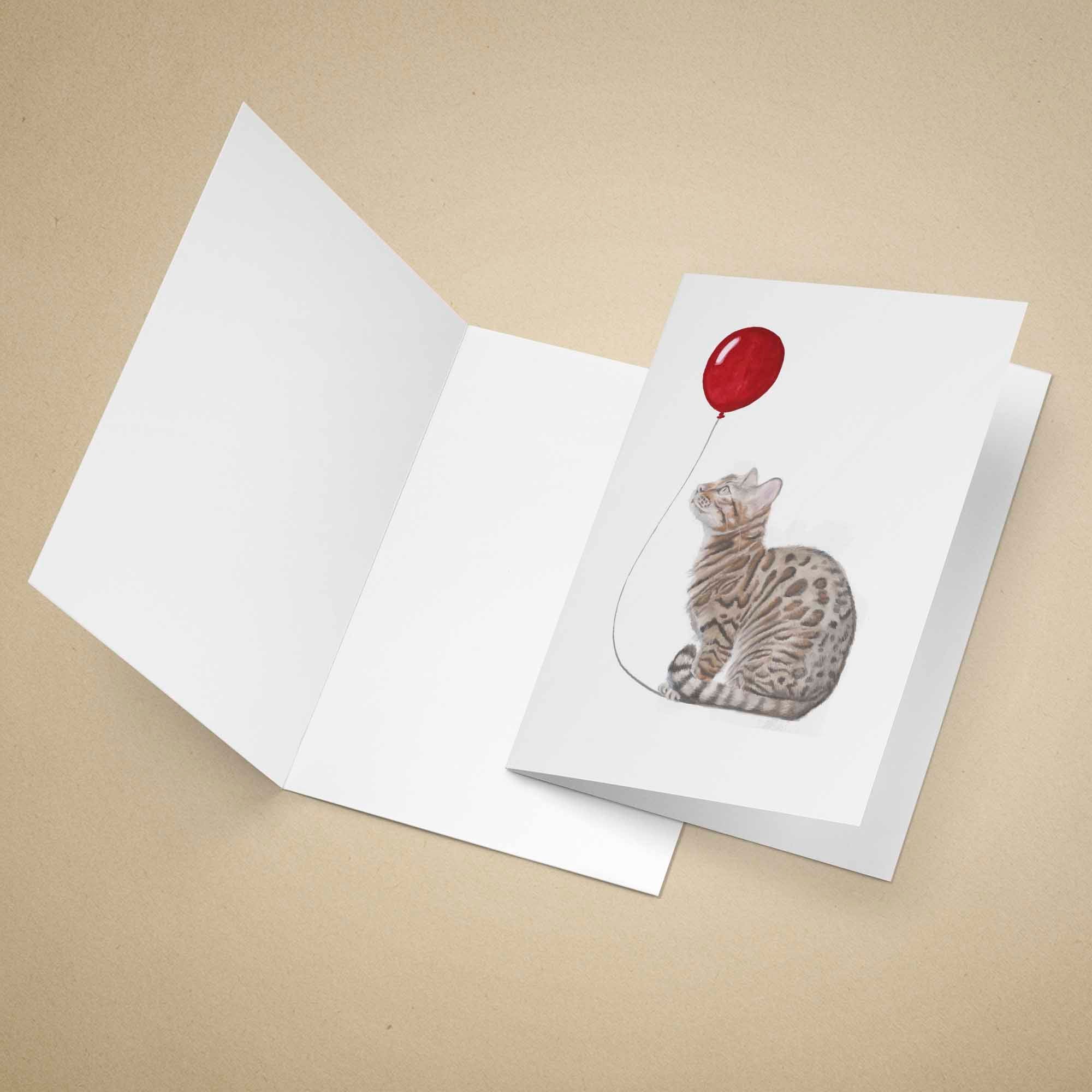 Greeting card with a Bengal cat and red balloon design on a beige background