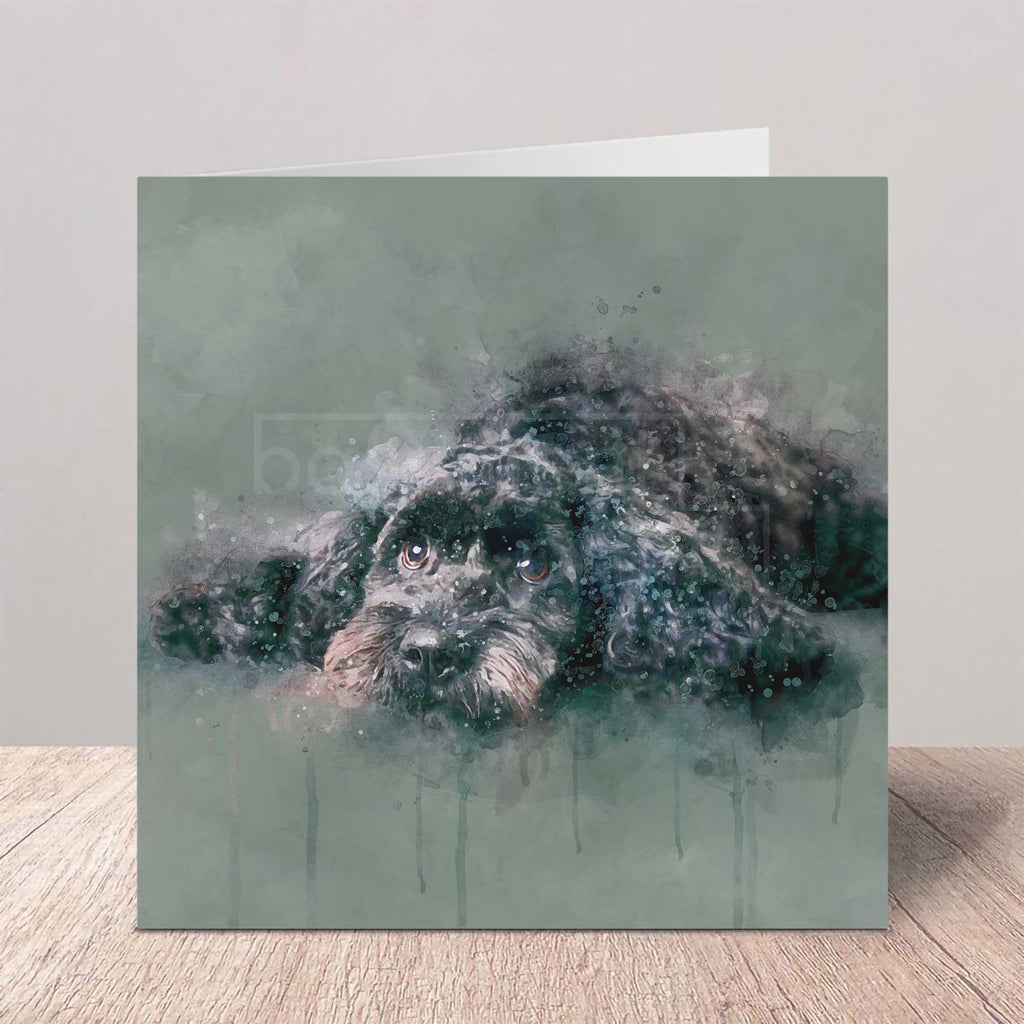 Greeting card with a cockapoo dog in watercolour design on a wooden surface.