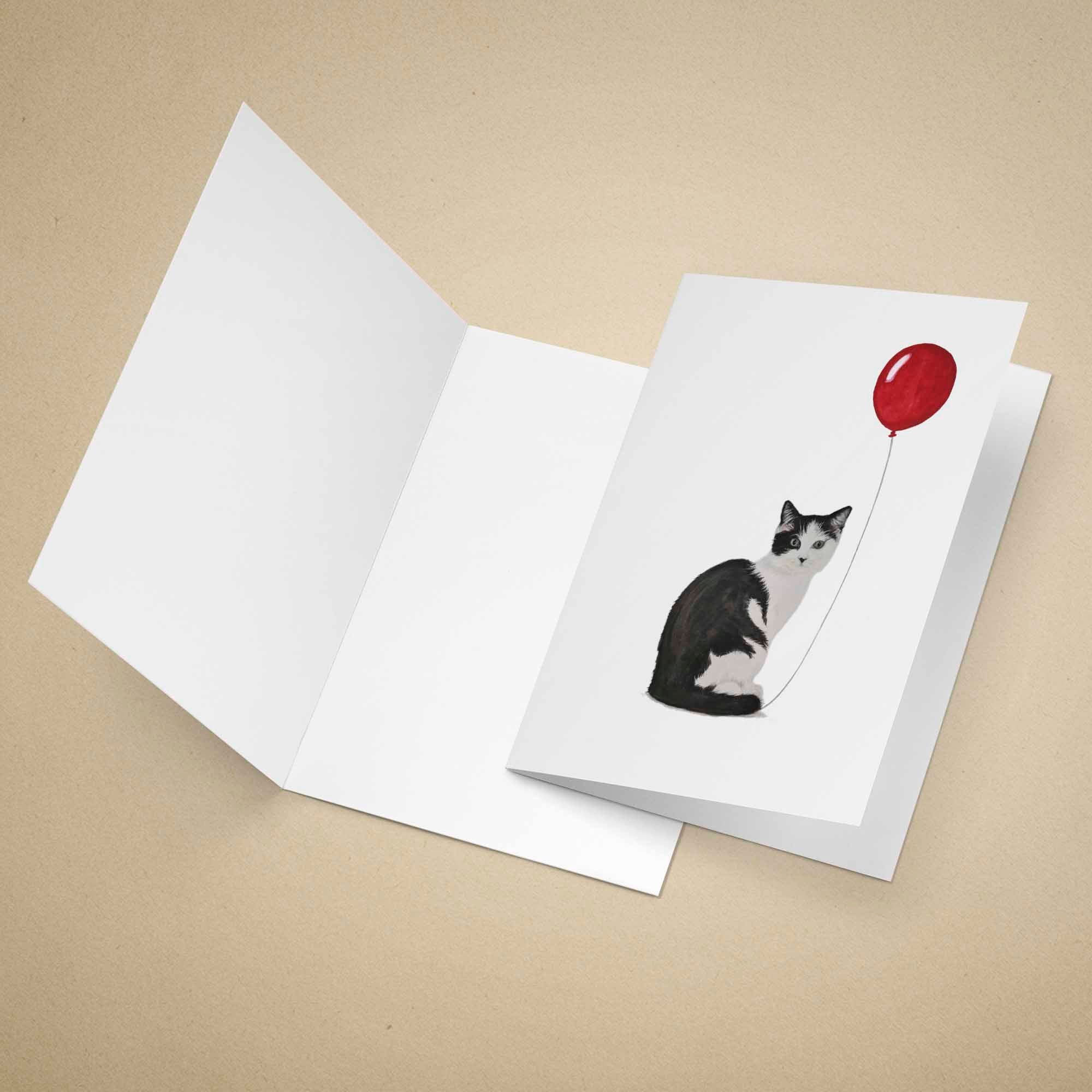 Greeting card with a cat holding a red balloon on a beige background