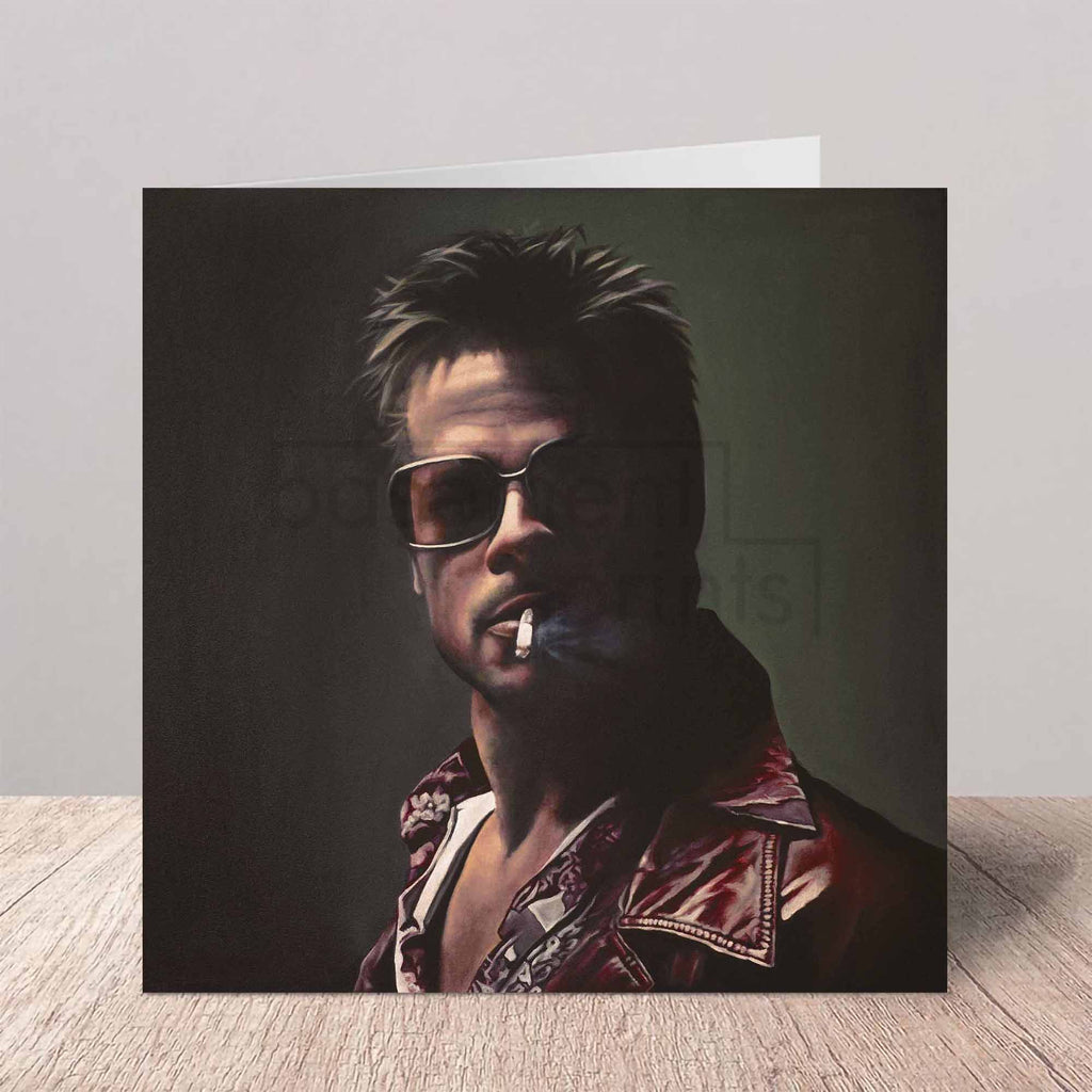 Greeting card with a portrait of Brad Pitt as Tyler Durden on a beige background a wooden surface.