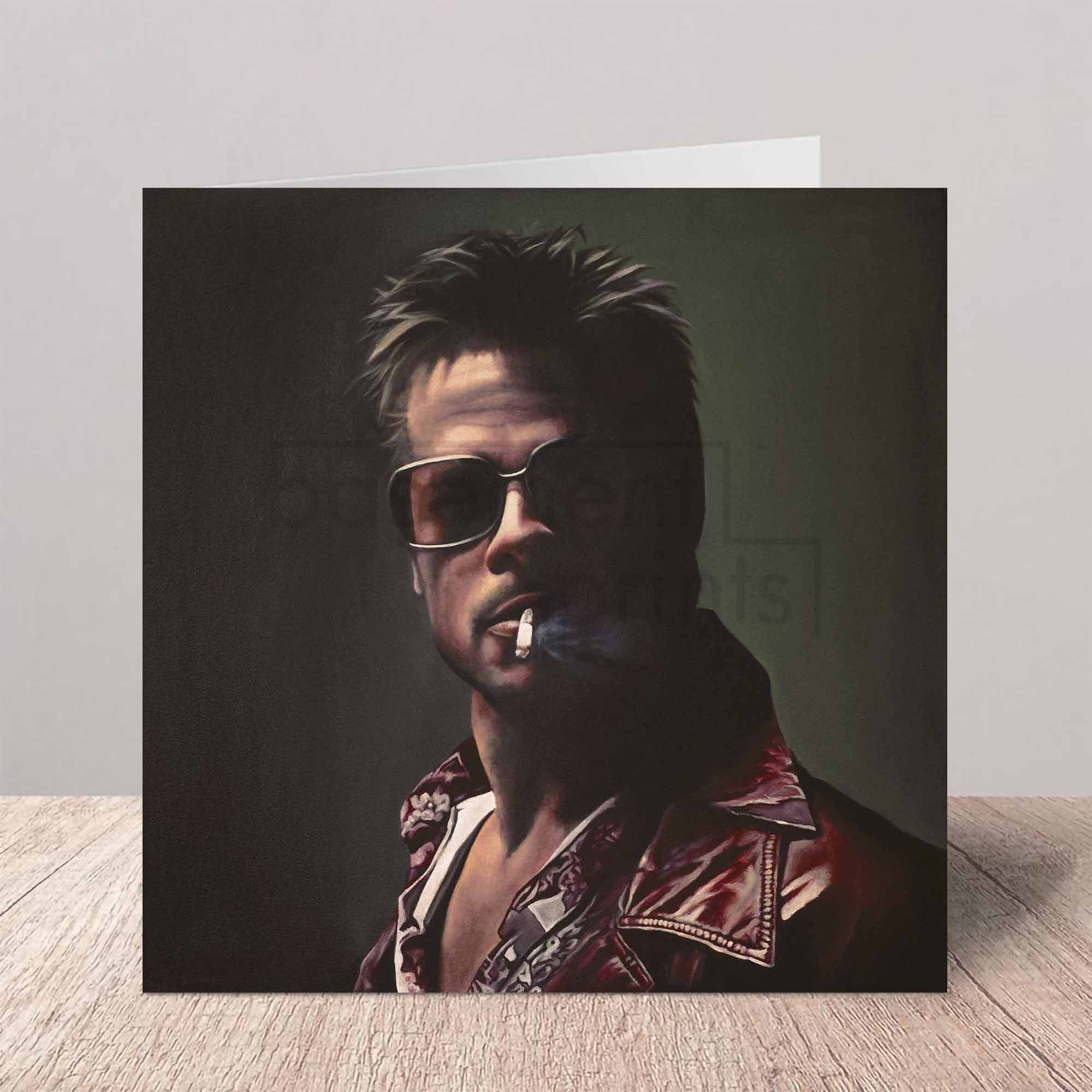 Greeting card with a portrait of Brad Pitt as Tyler Durden on a beige background a wooden surface.