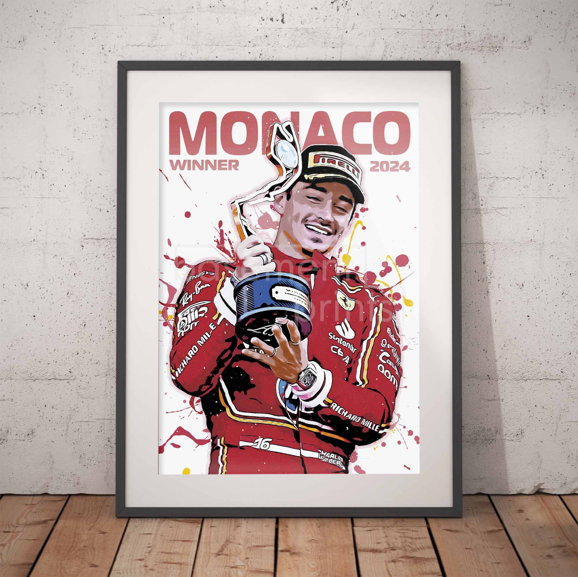 Framed poster of a Formula 1 driver Charles Leclerc celebrating with a trophy, set against a white brick wall.