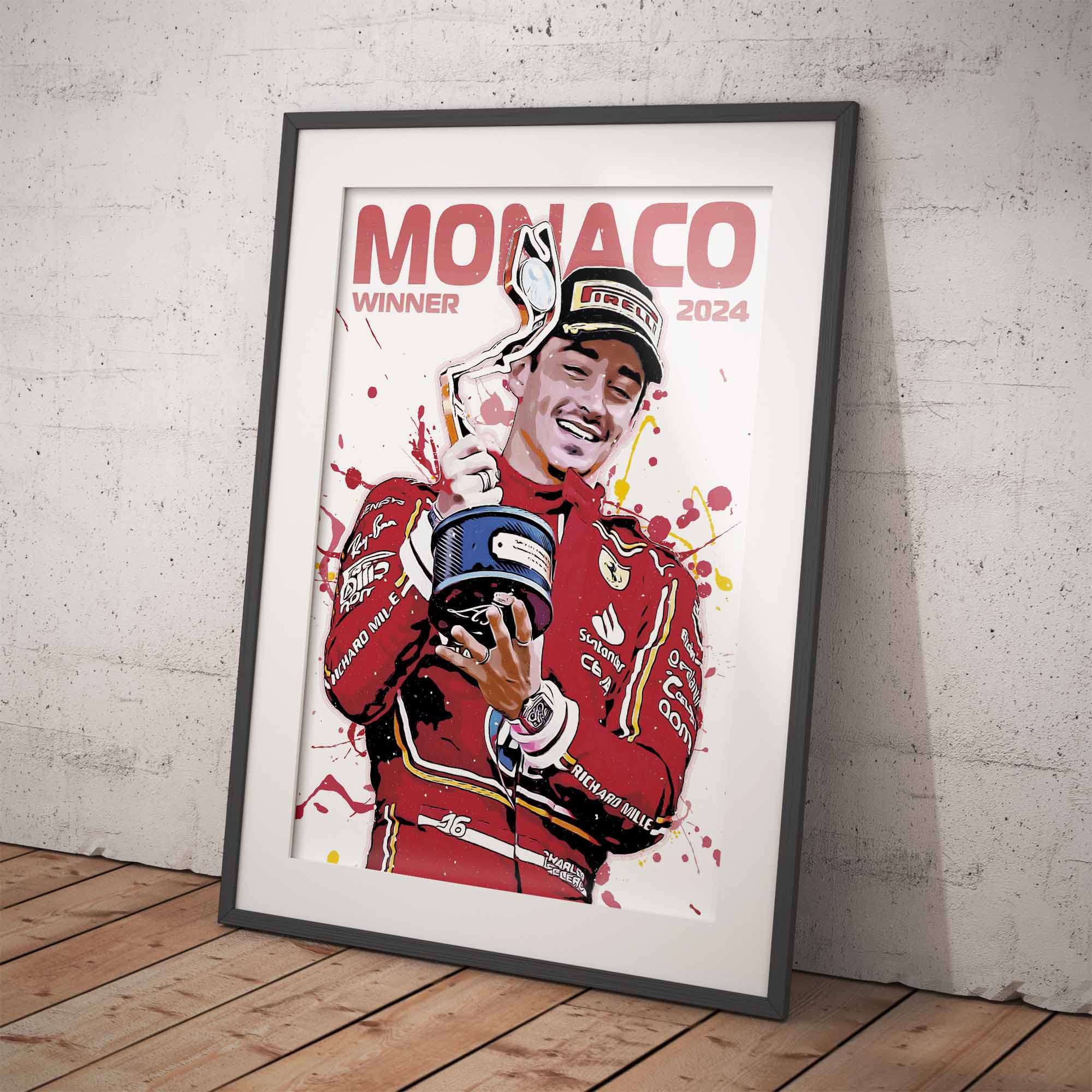 Framed poster of a Formula 1 driver Charles Leclerc holding a trophy with 'Monaco Winner 2024' text on a white wall.