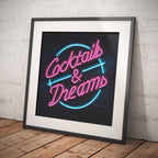 Framed neon sign with 'Cocktails & Dreams' text on a brick wall background